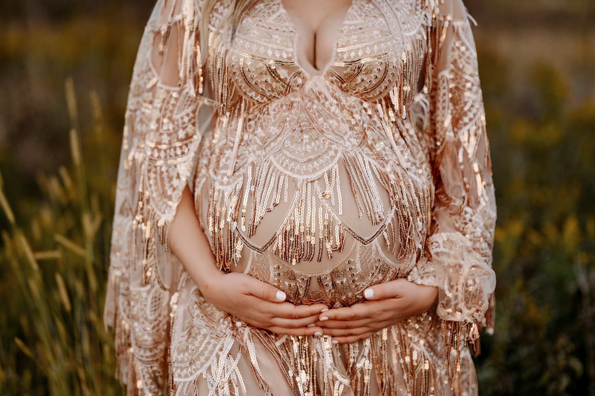 Grand Rapids newborn photography by Honeywild Photo: Newborn baby peacefully sleeping on a soft white blanket, wearing a rainbow knit hat. Capturing warm, timeless moments with professional newborn photography in Grand Rapids, MI.