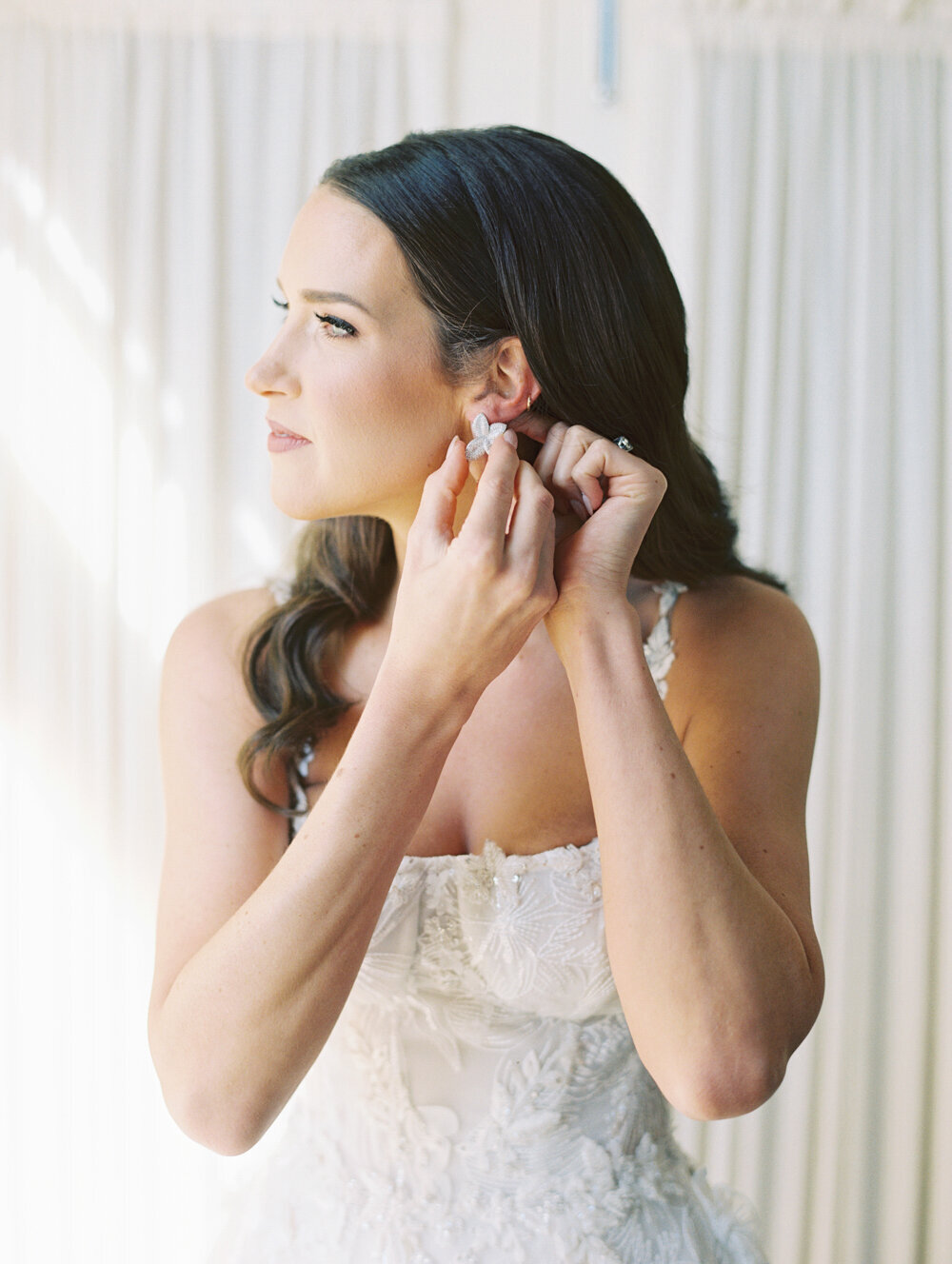 bride putting on earrings