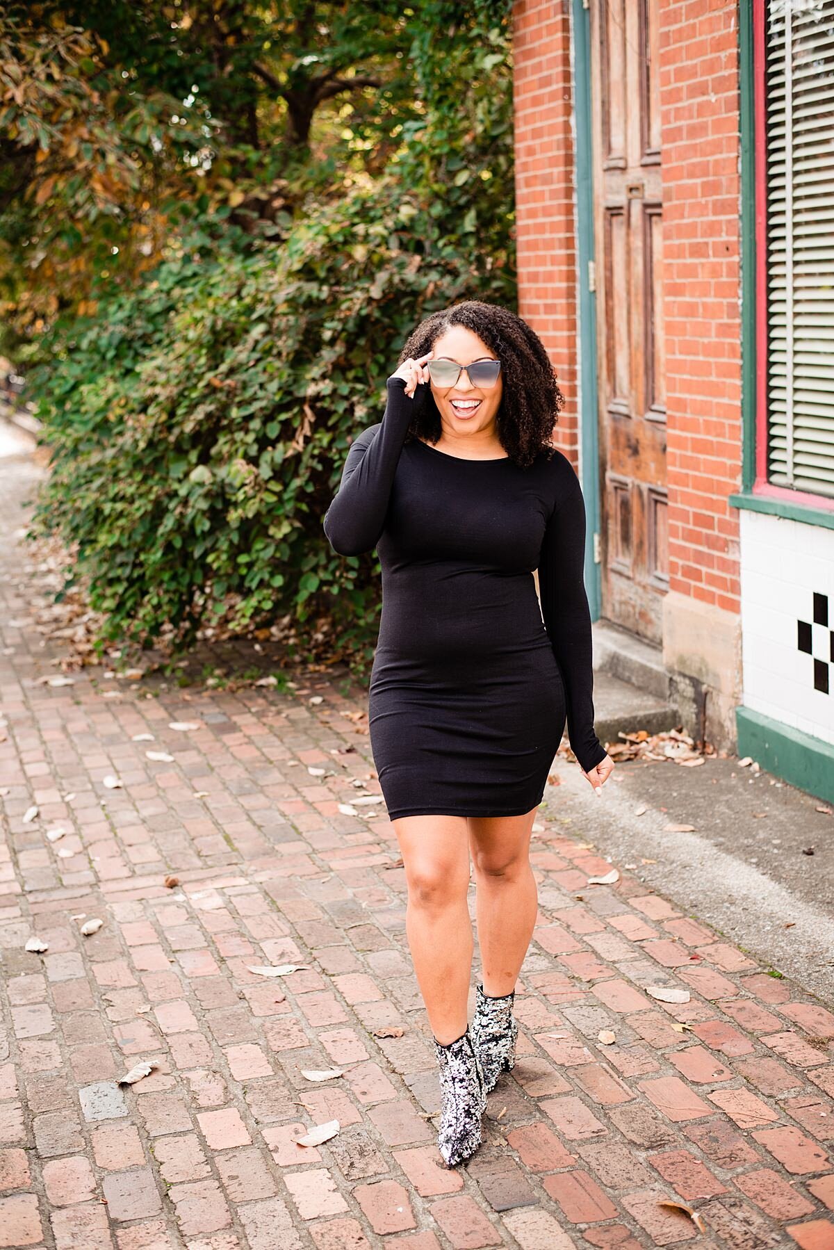 Social influencer modeling clothes in Germantown near Nashville on brick cobblestone sidewalk