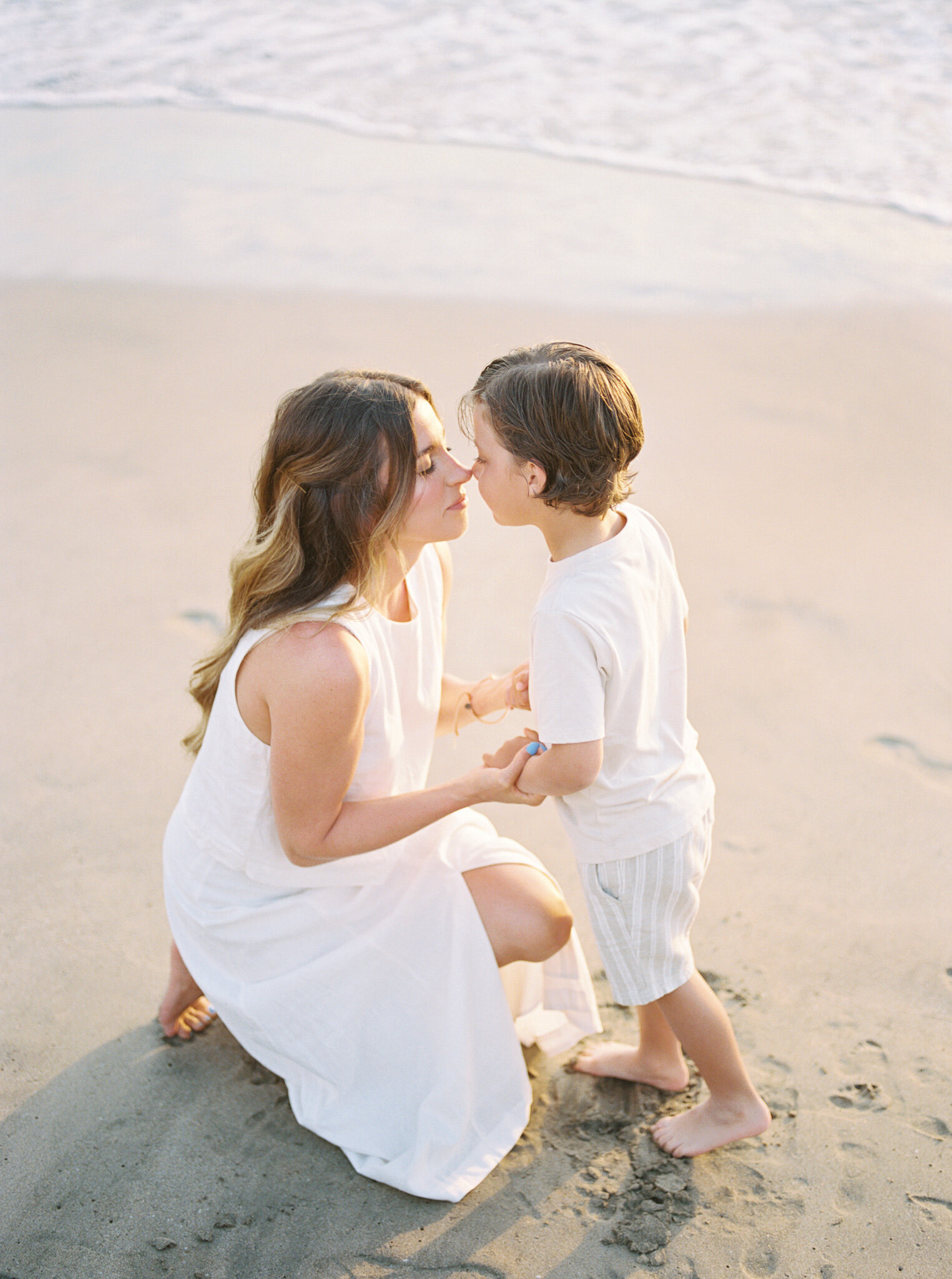Photographer Little Rock Bailey Feeler kneels in the sand on a Mexican beach, nose to nose with her young son.