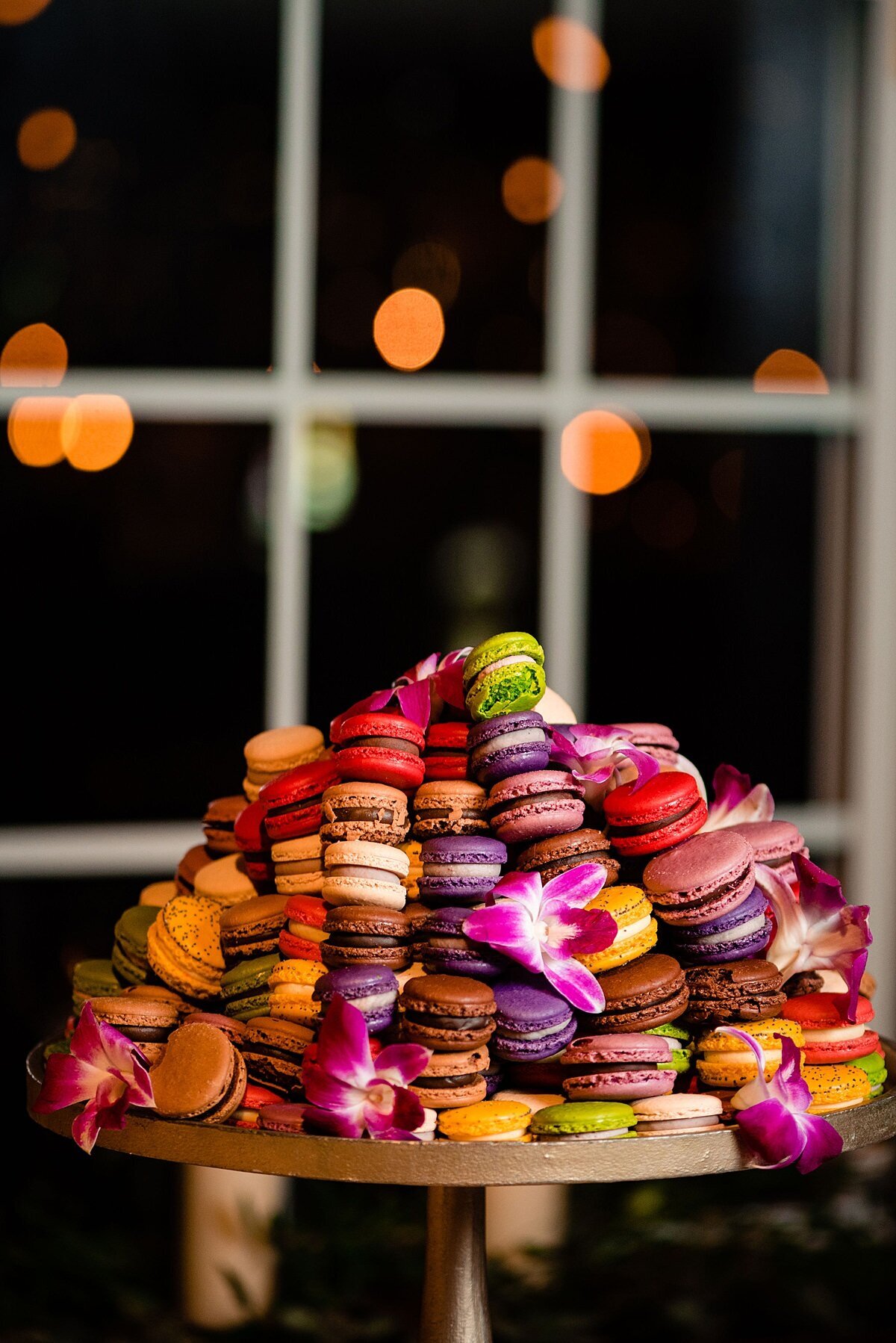 Mini macaroons stacked together on golden tray to make a tower