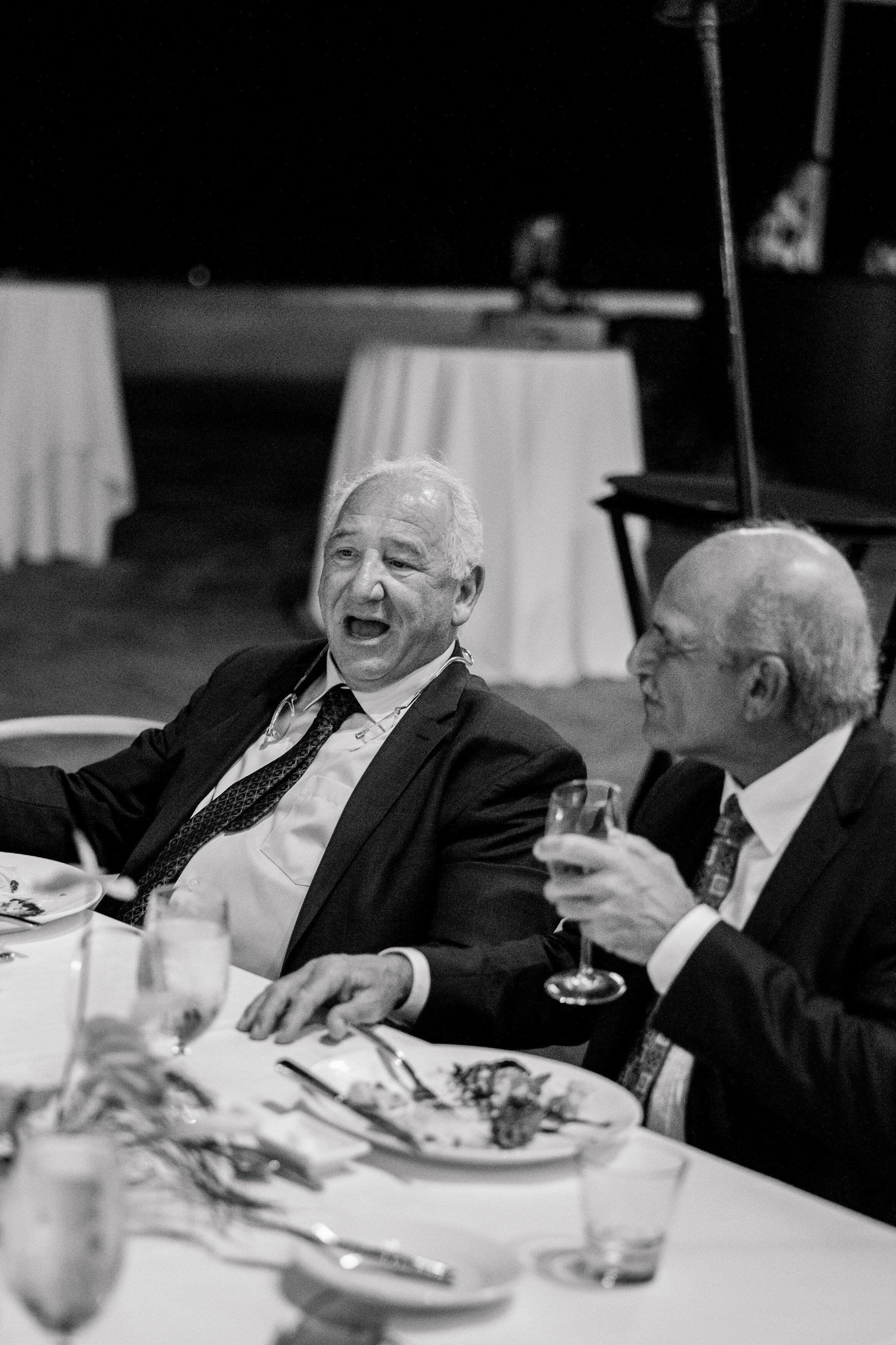 Wedding and Elopement Photographer, black and white image of old men talking at reception