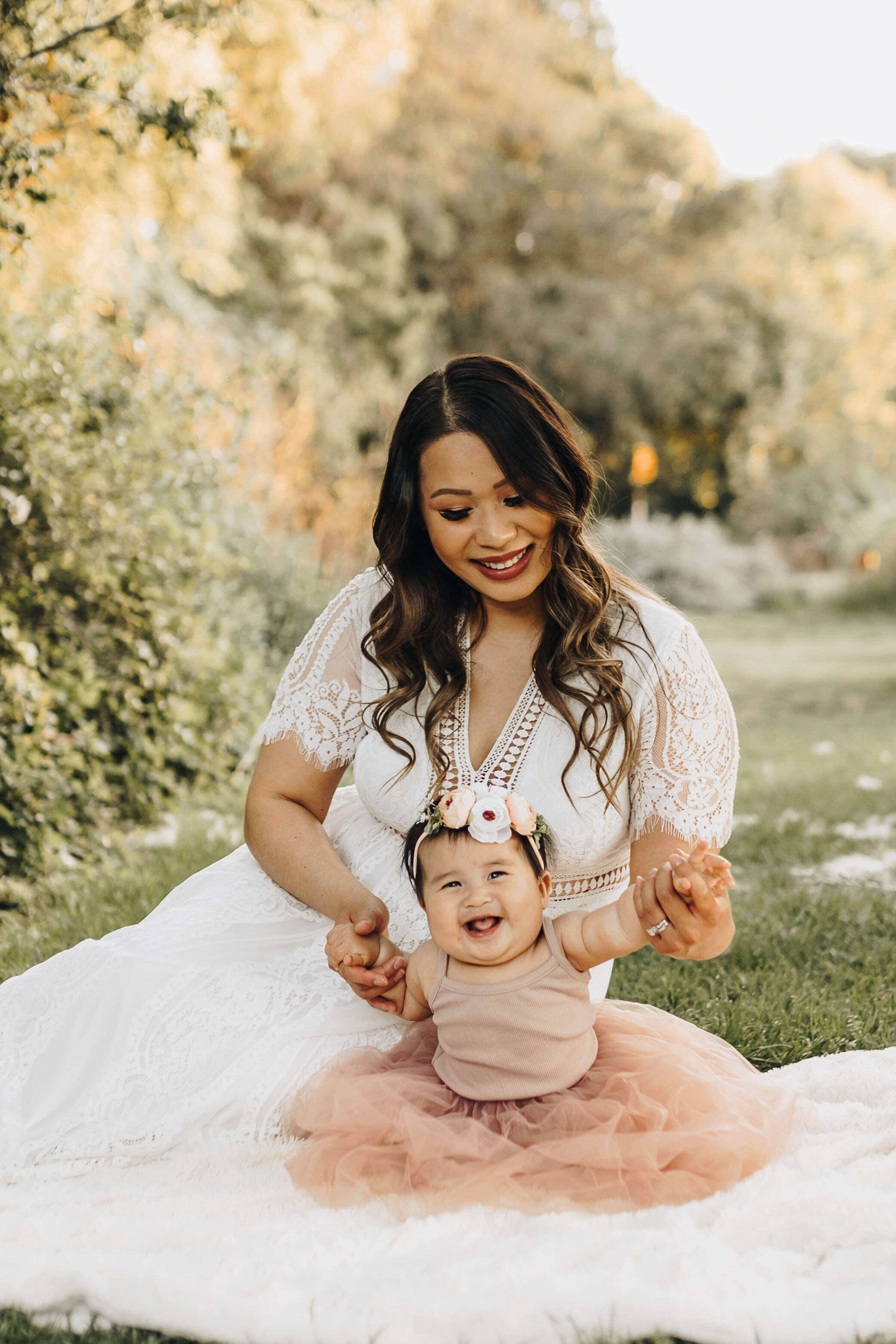 little girl sits with her mom in the garden