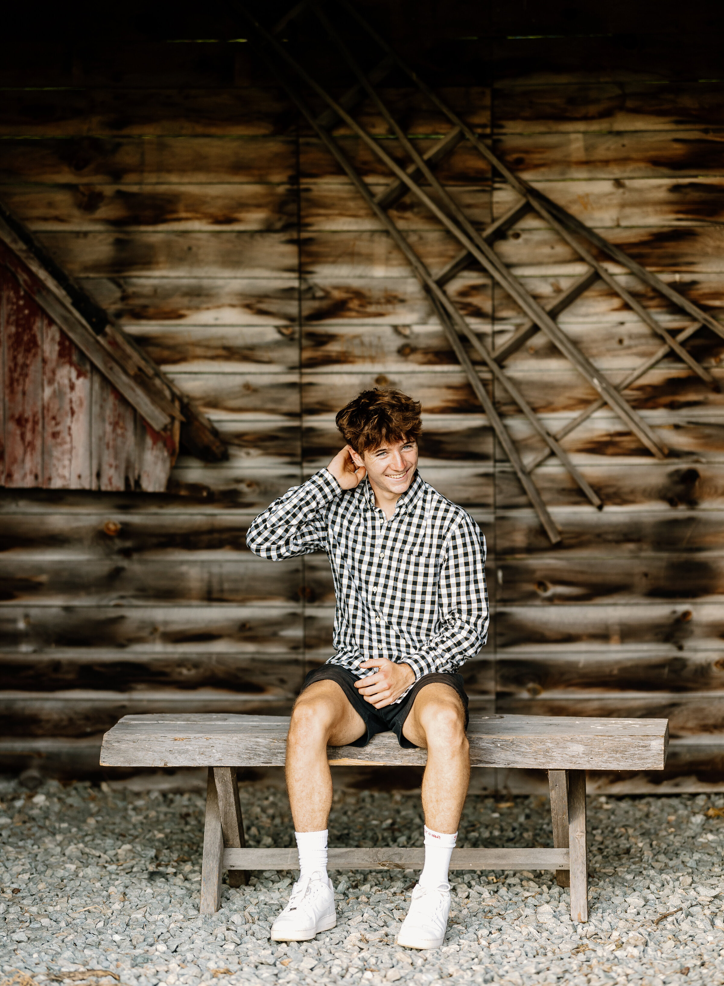 Senior boy photo in barn smiling at the camera