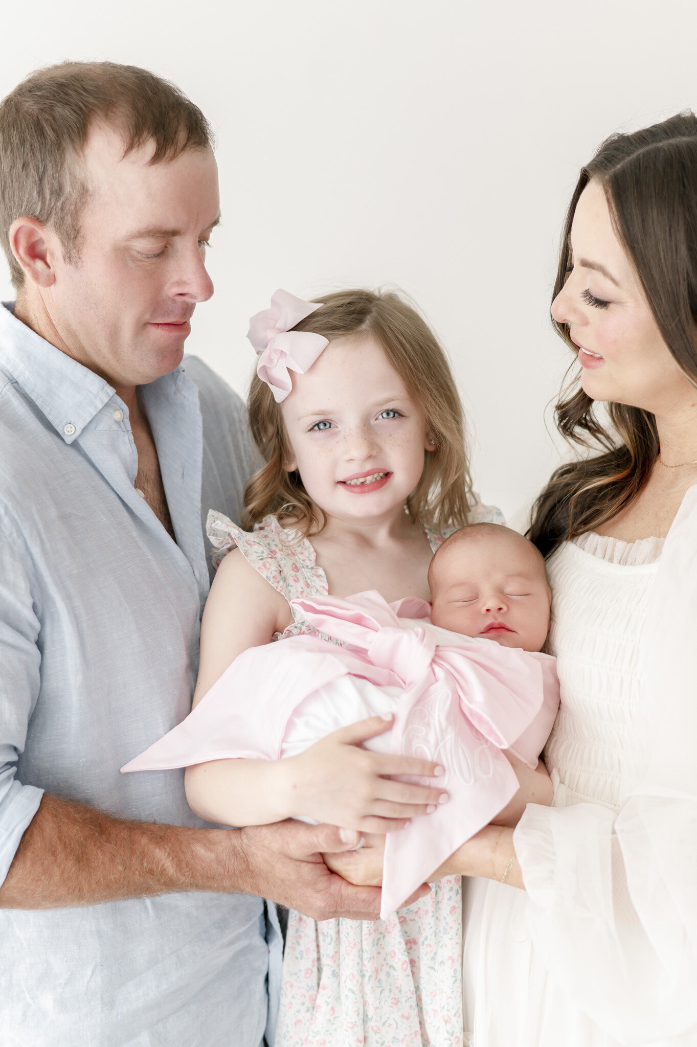 a big sister holds her newborn sister for a family newborn photo shoot in nashville