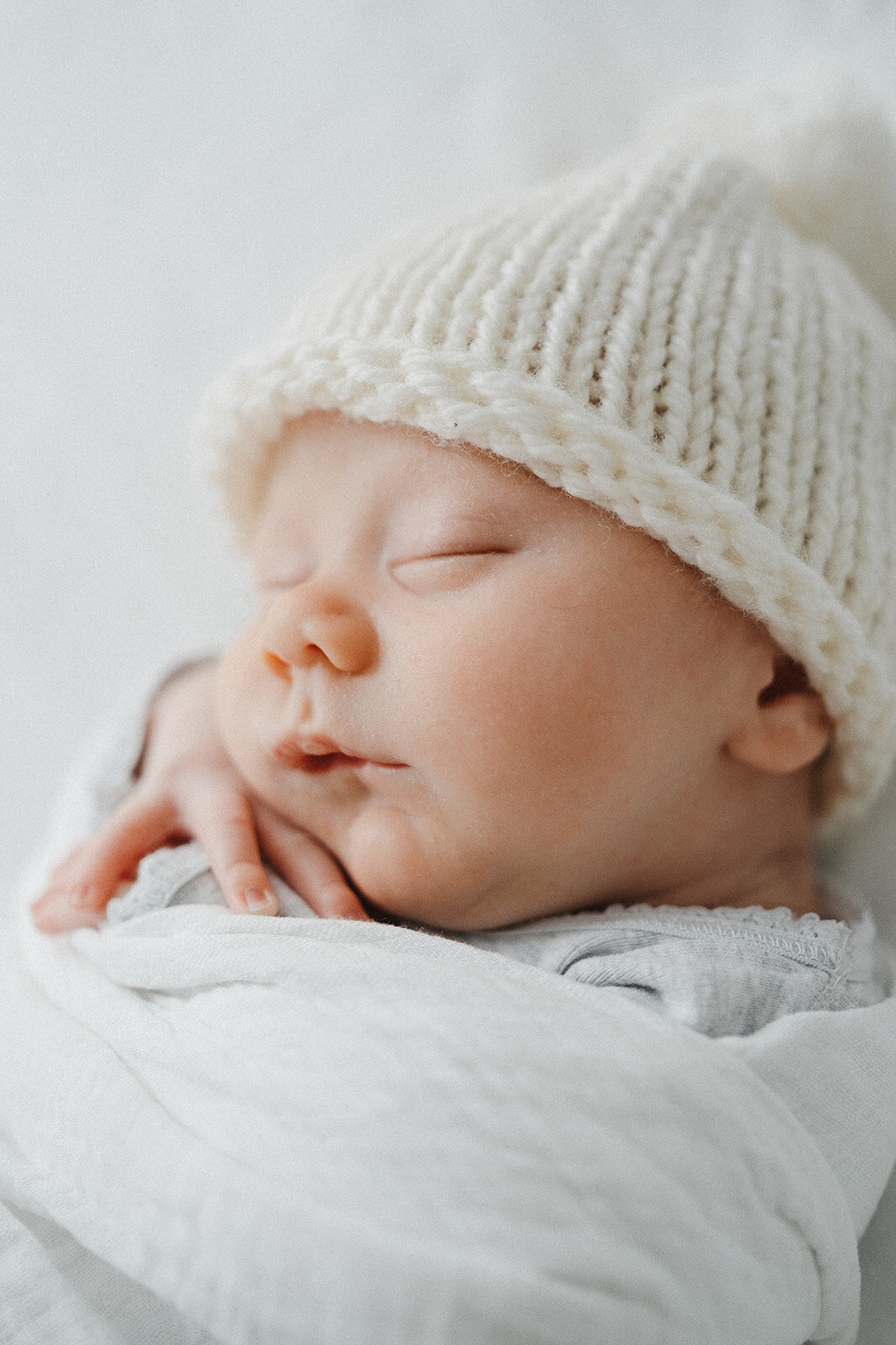 newborn with knitted beanie sleeping