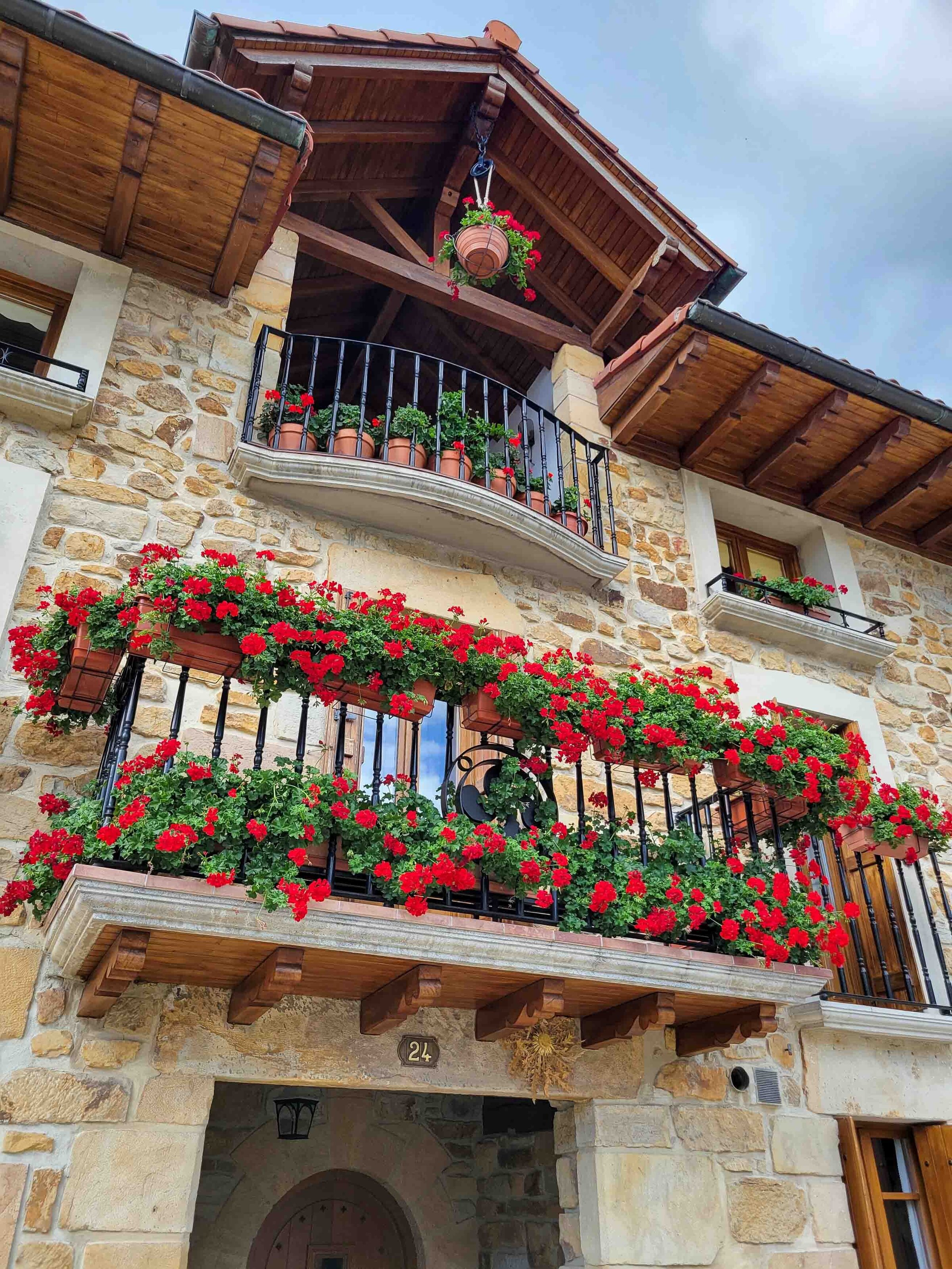 Red geraniums lining a balcony of a traditional stone house in Navarre, Spain ©Stephanie Dosch | theViatrix Luxury Travel