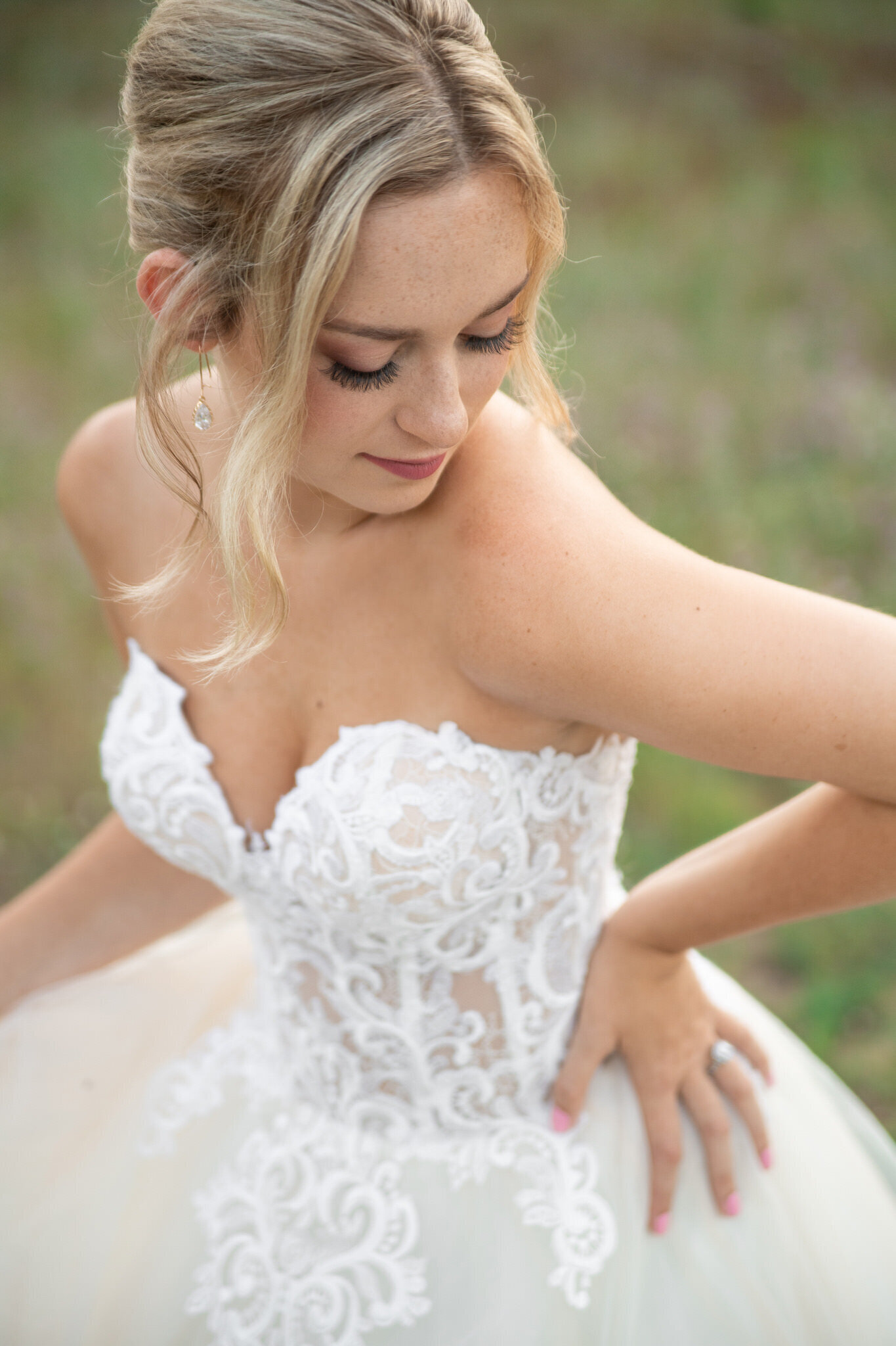 blonde bride looking down at her strapless wedding dress