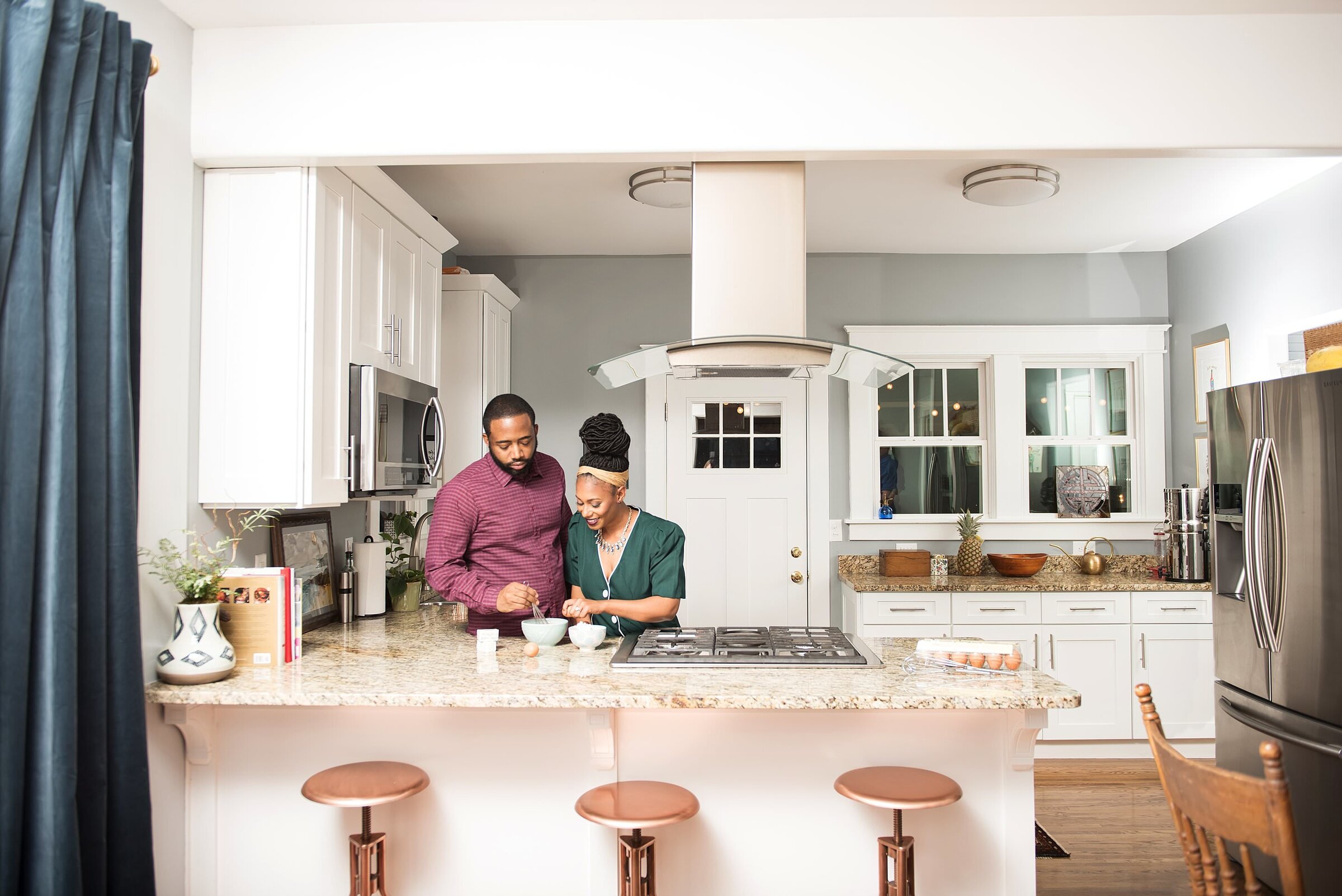 Couple working in modern kitchen side by side putting together ingredients for cookies