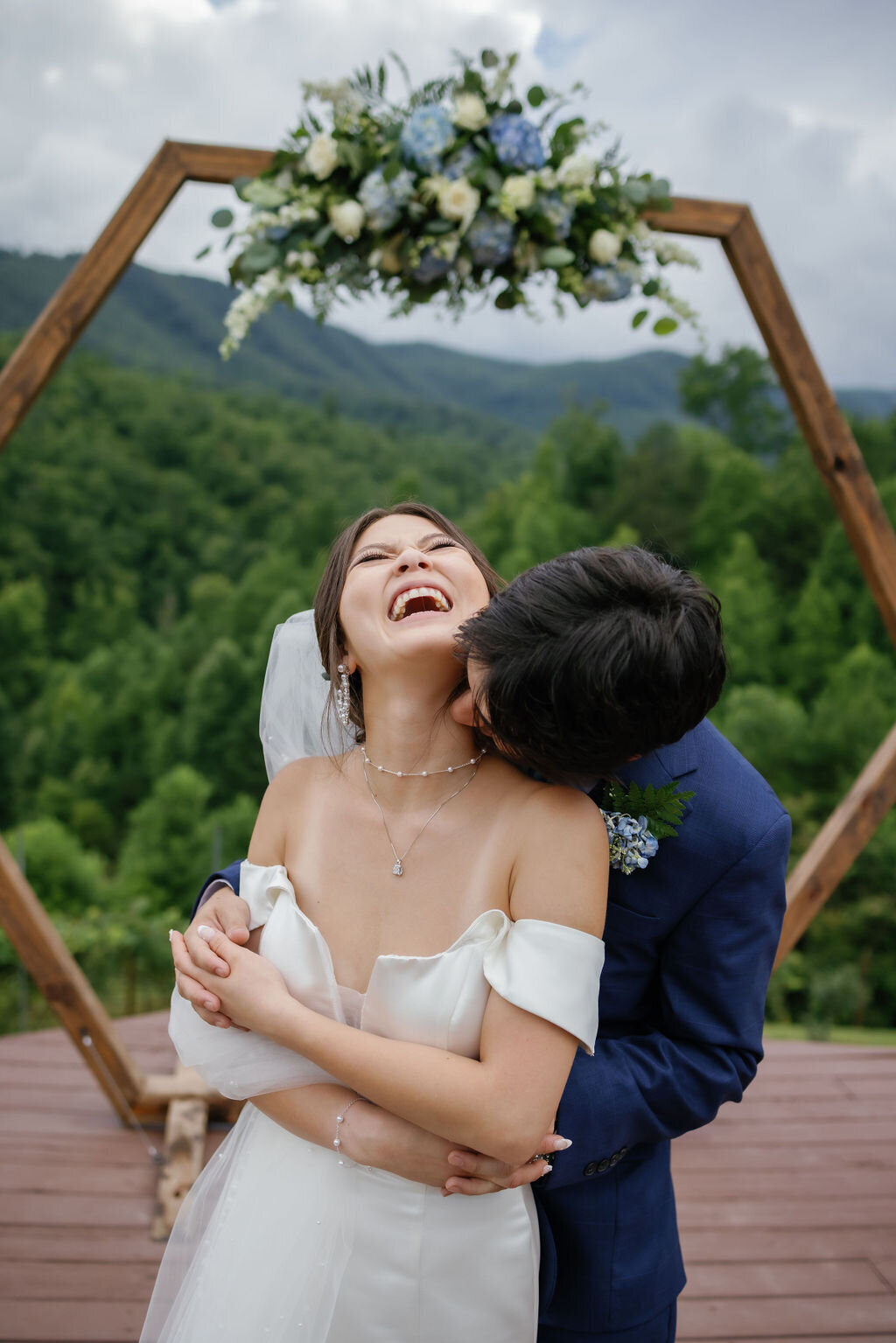 candid wedding photo for a couple eloping to gatlinburg with the groom kissing the brides neck as the throws her head back and laughs