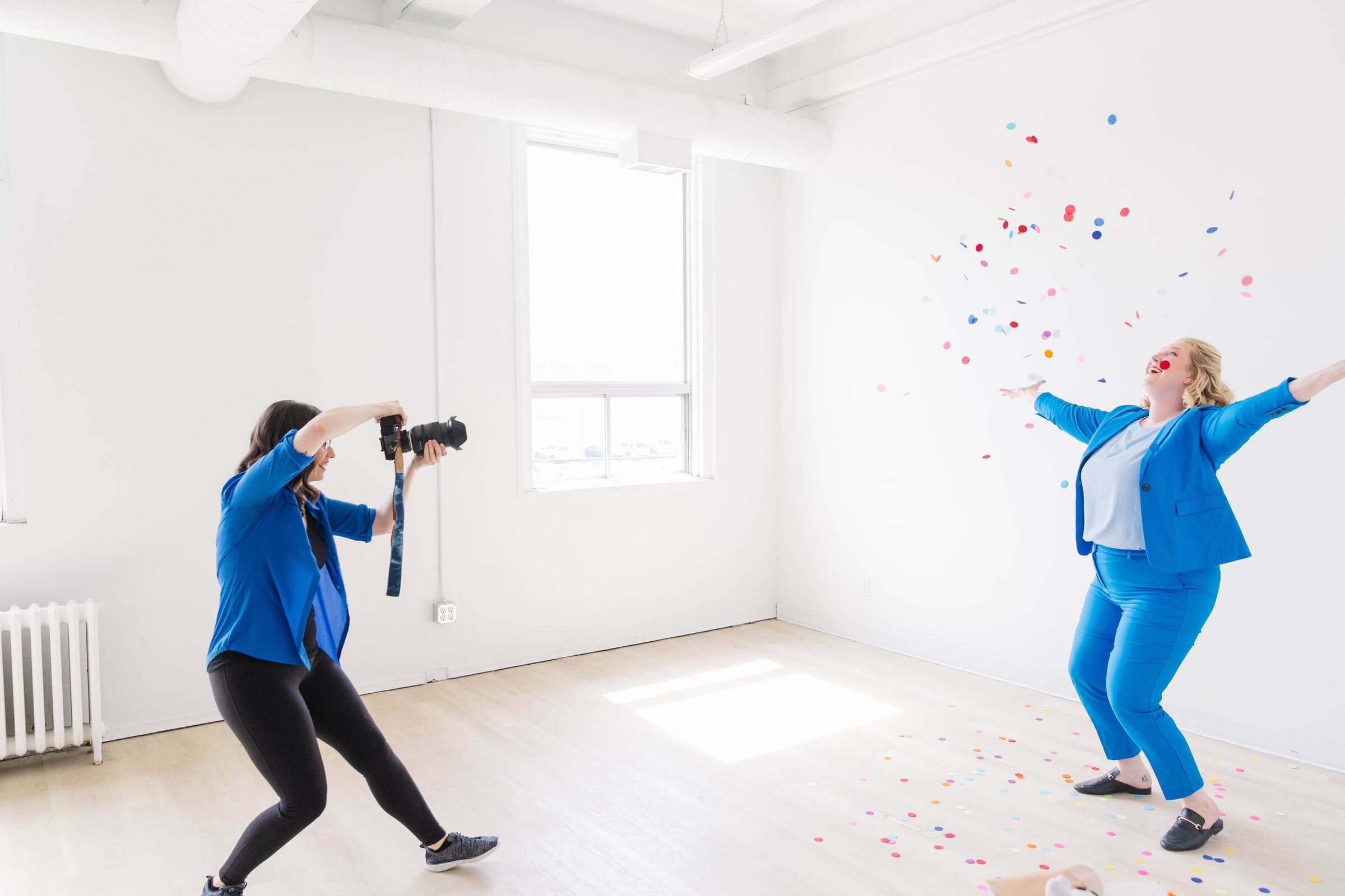 Travel agent throwing confetti and celebrating a win while photographer is capturing the moment at Ottawa studio