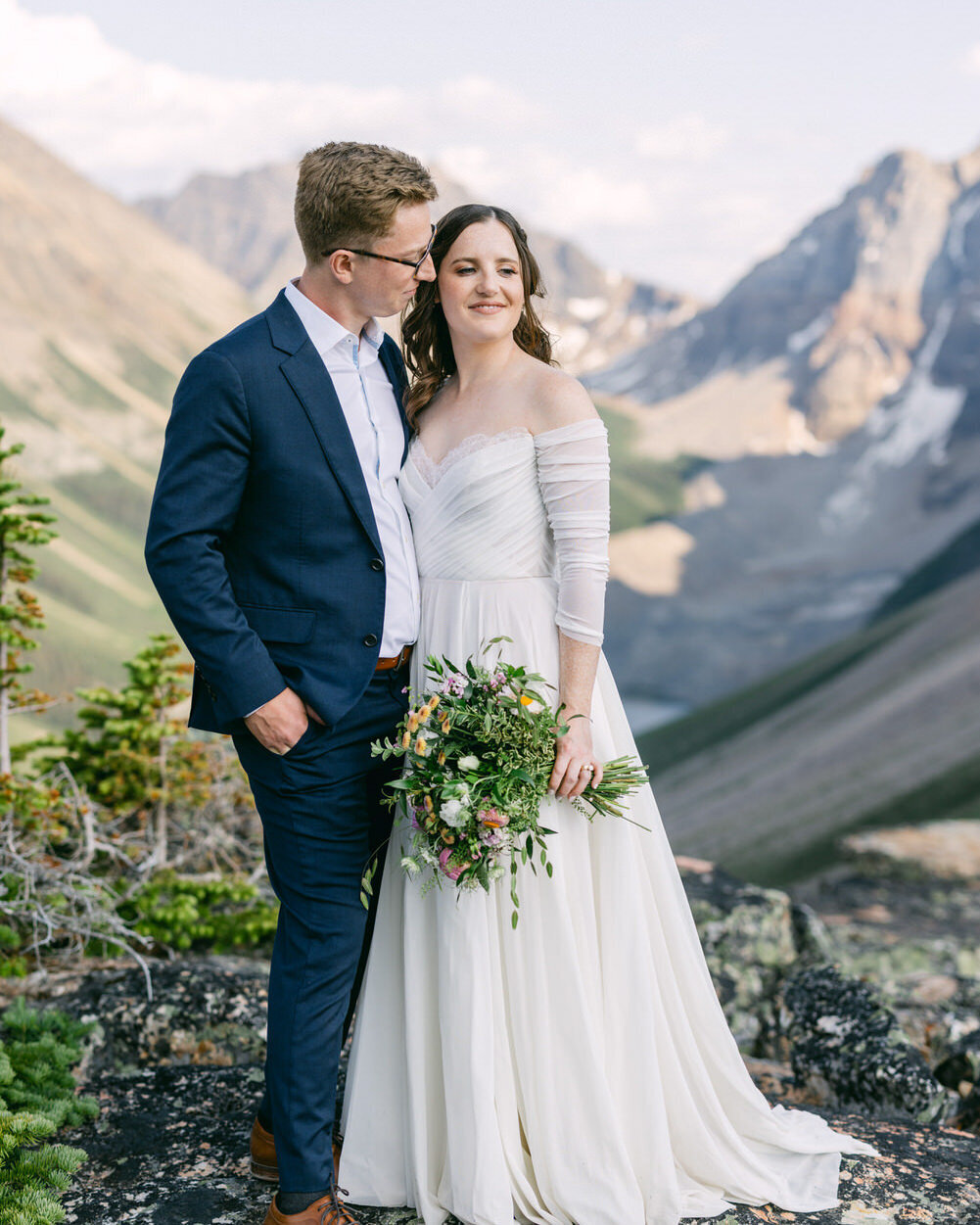 This breathtaking image captures the bride and groom holding each other at the summit of the Tower of Babel, following their wedding ceremony at Moraine Lake. After a thrilling scramble to the top, the couple’s love and adventure are beautifully framed by the dramatic mountain landscape.