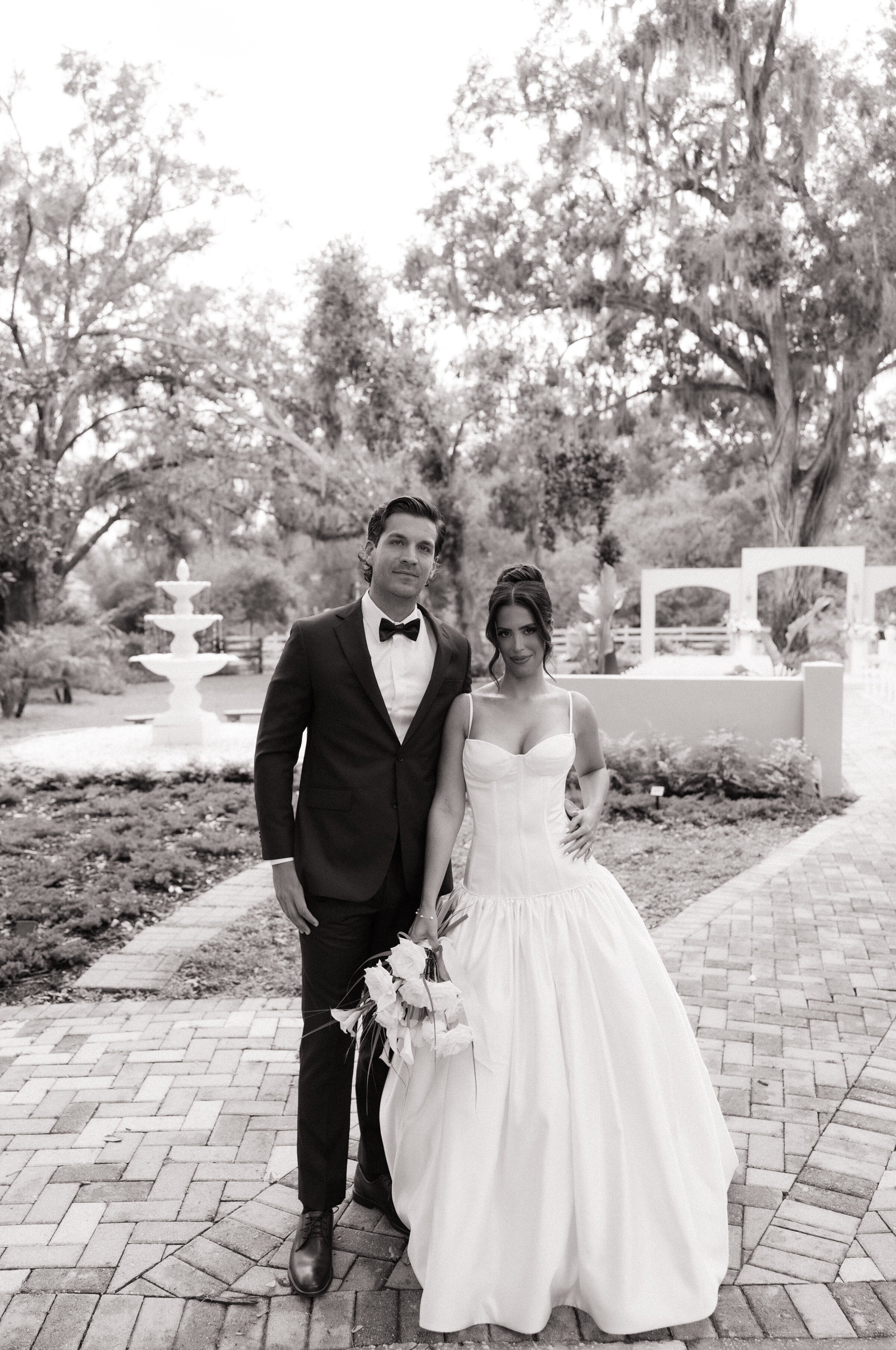 Black and white photo of a bride and groom walking the garden pathway at Uliana Estate in Lakeland, Florida


