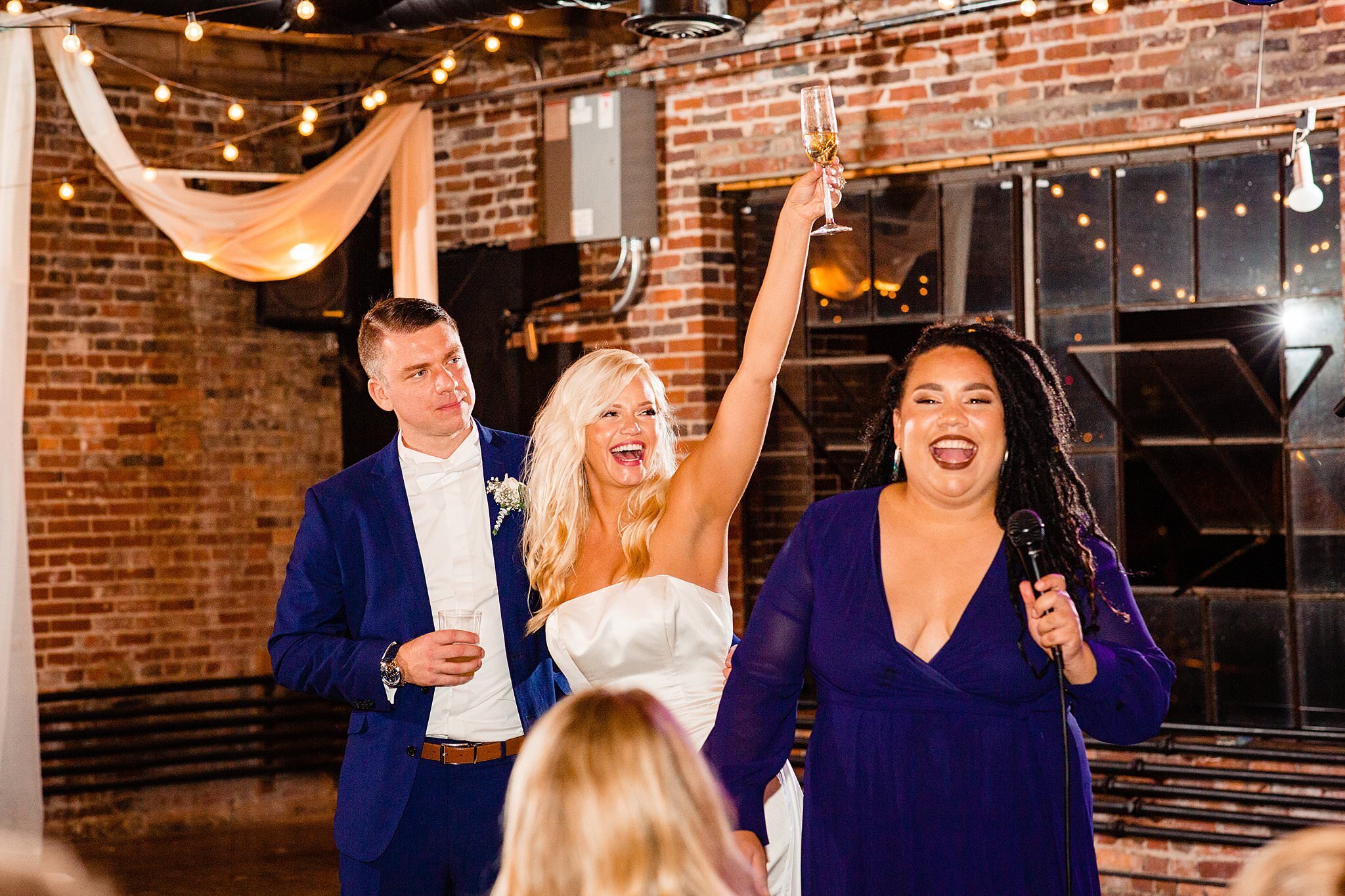 Bride raising a champagne flute as maid of honor toasts the happy couple