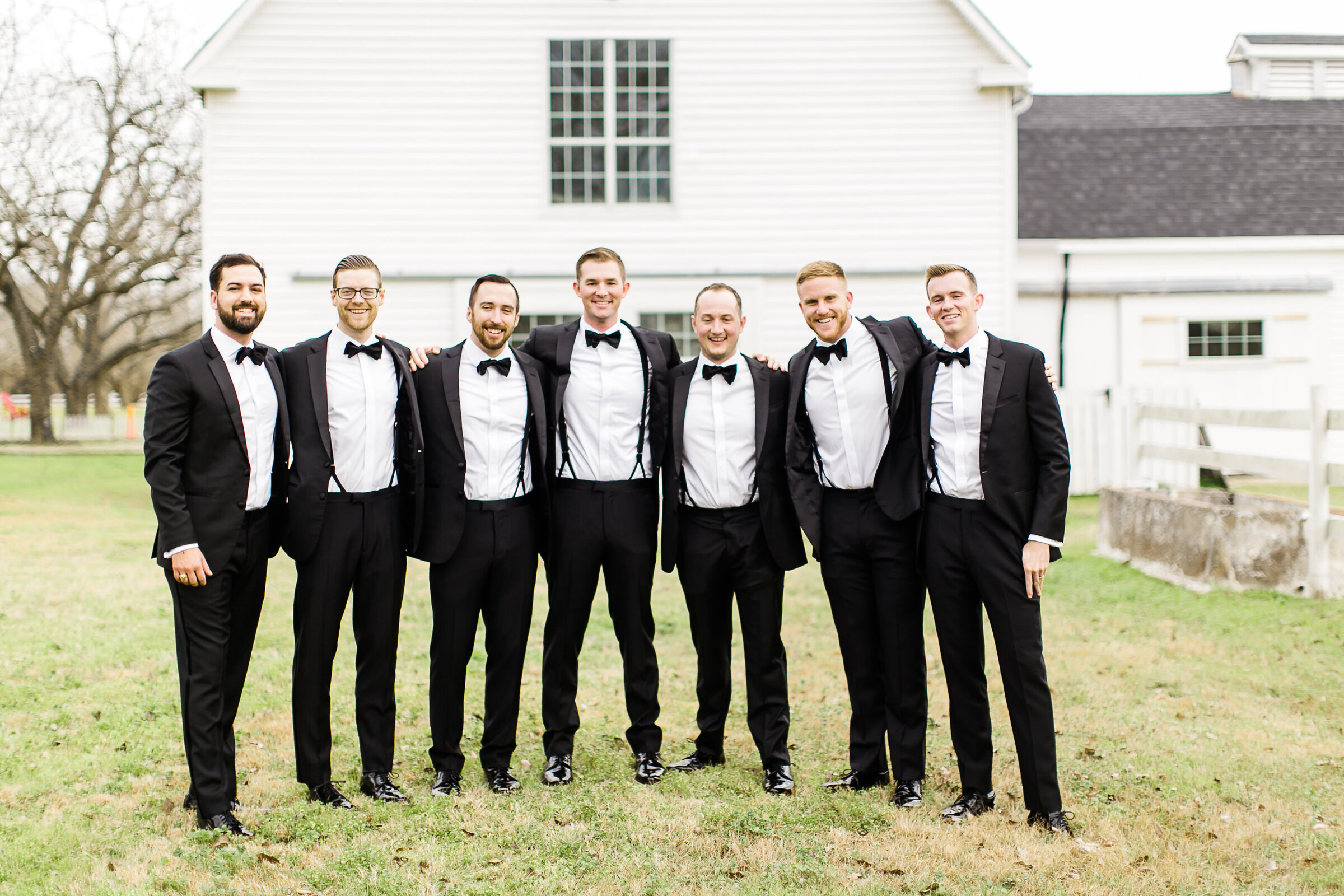 A group of groomsmen standing in front of the dairy barn at the Grand Texana