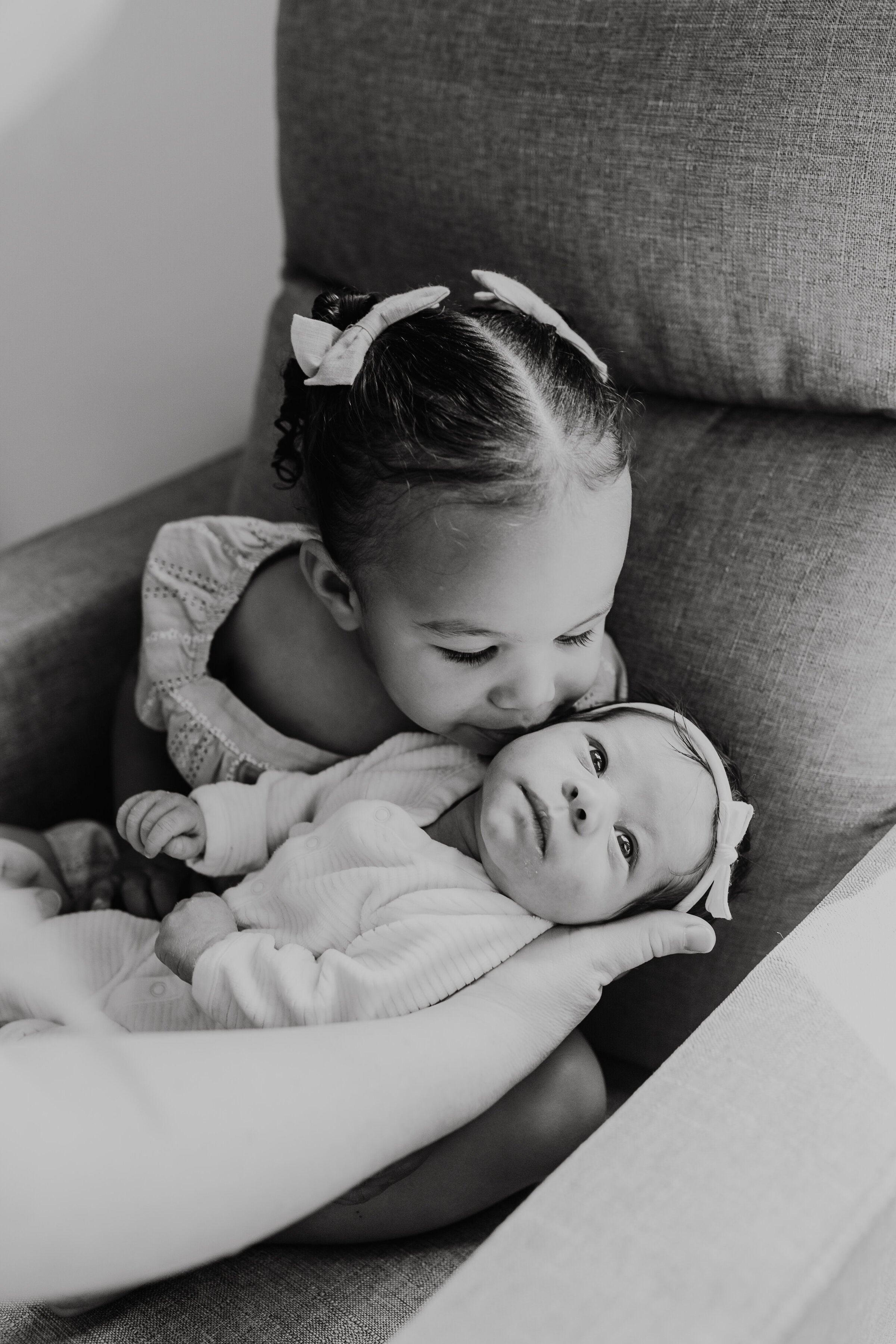 Sibling kisses baby sister