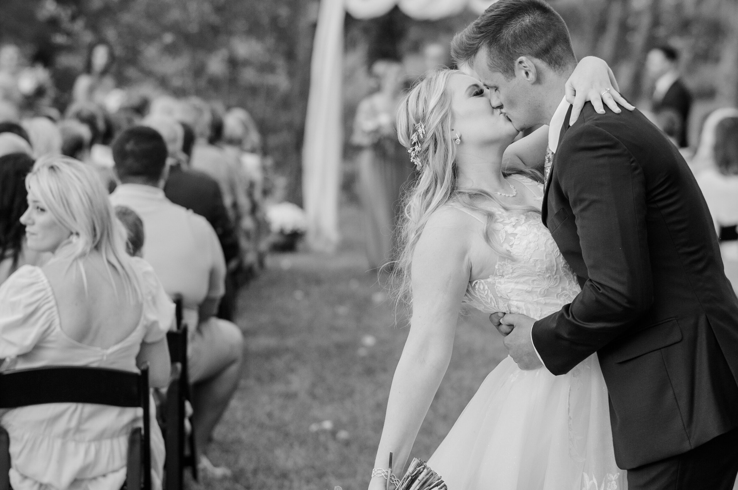 Bride and Groom sharing a kiss at the end of the aisle