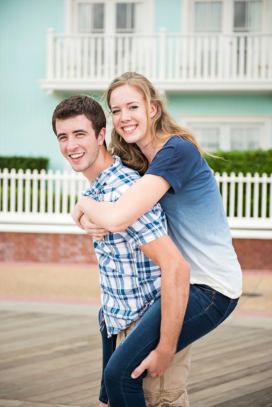 Guy giving his girlfriend a piggyback ride  on the boardwalk at the Walt Disney World Boardwalk Hotel