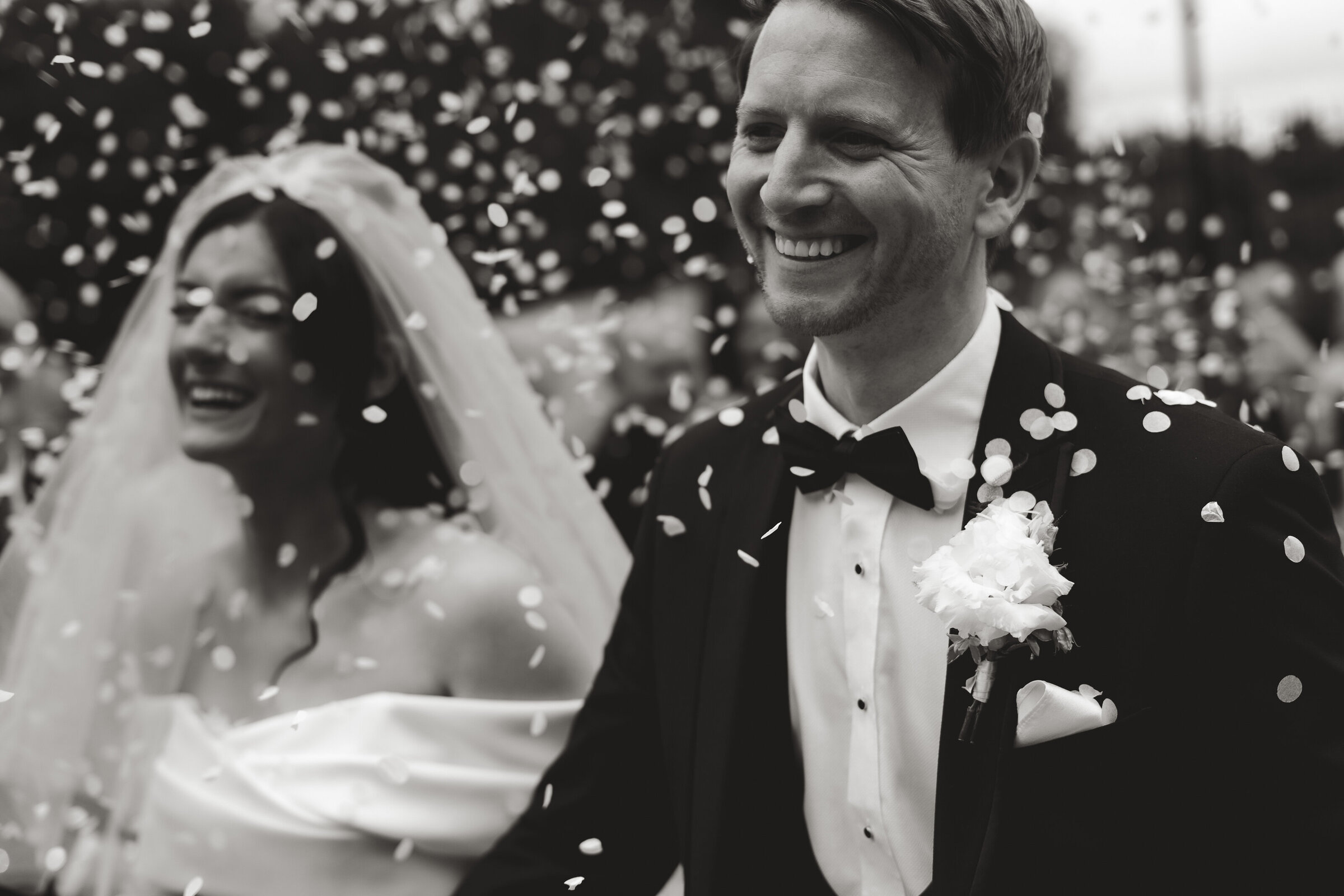 close of groom during confetti moment of his wedding day, smiling and happy 
