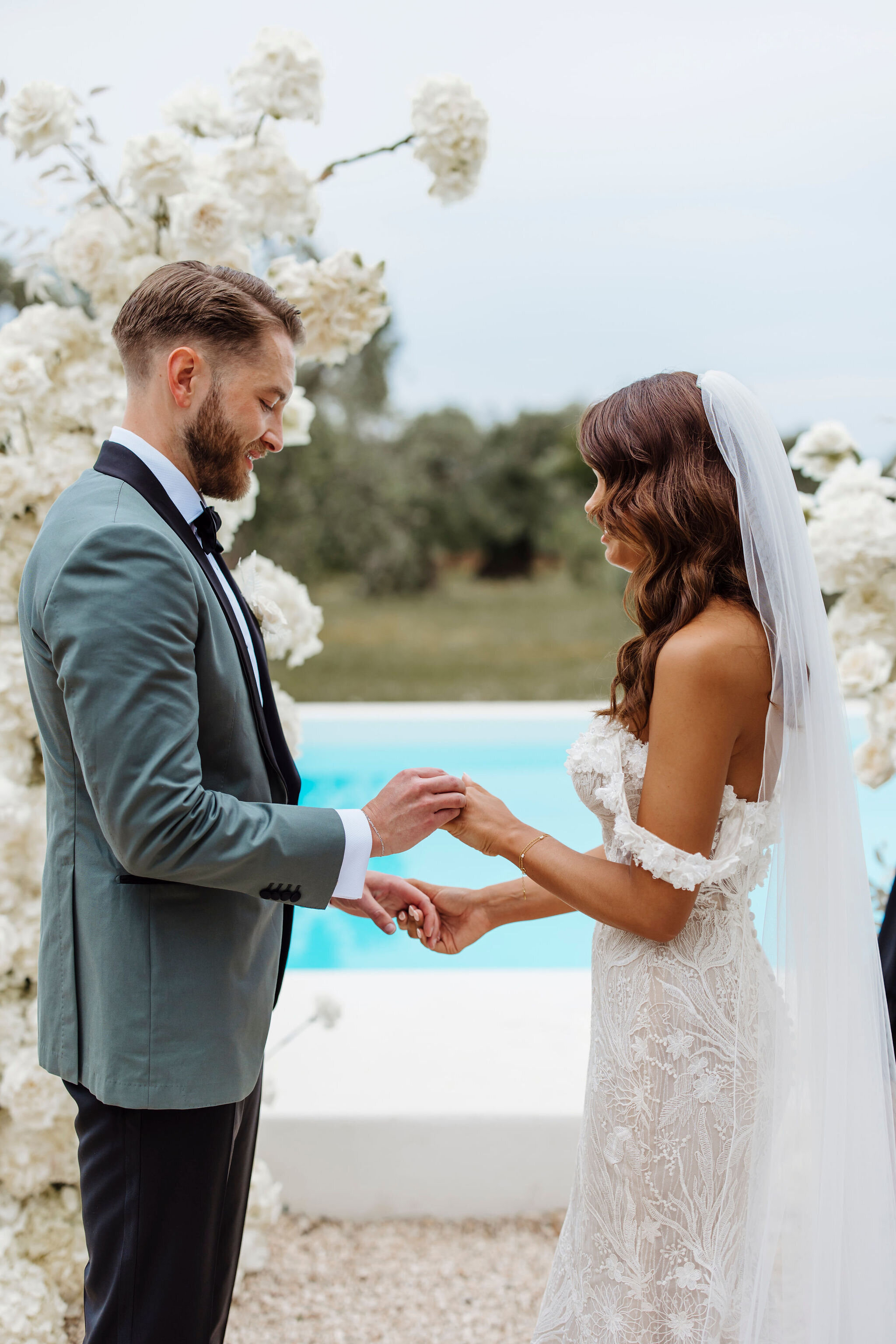 Nicky and Jack standing at the altar as they exchange vows at their wedding ceremony by the pool of Masseria Moroseta, Ostuni