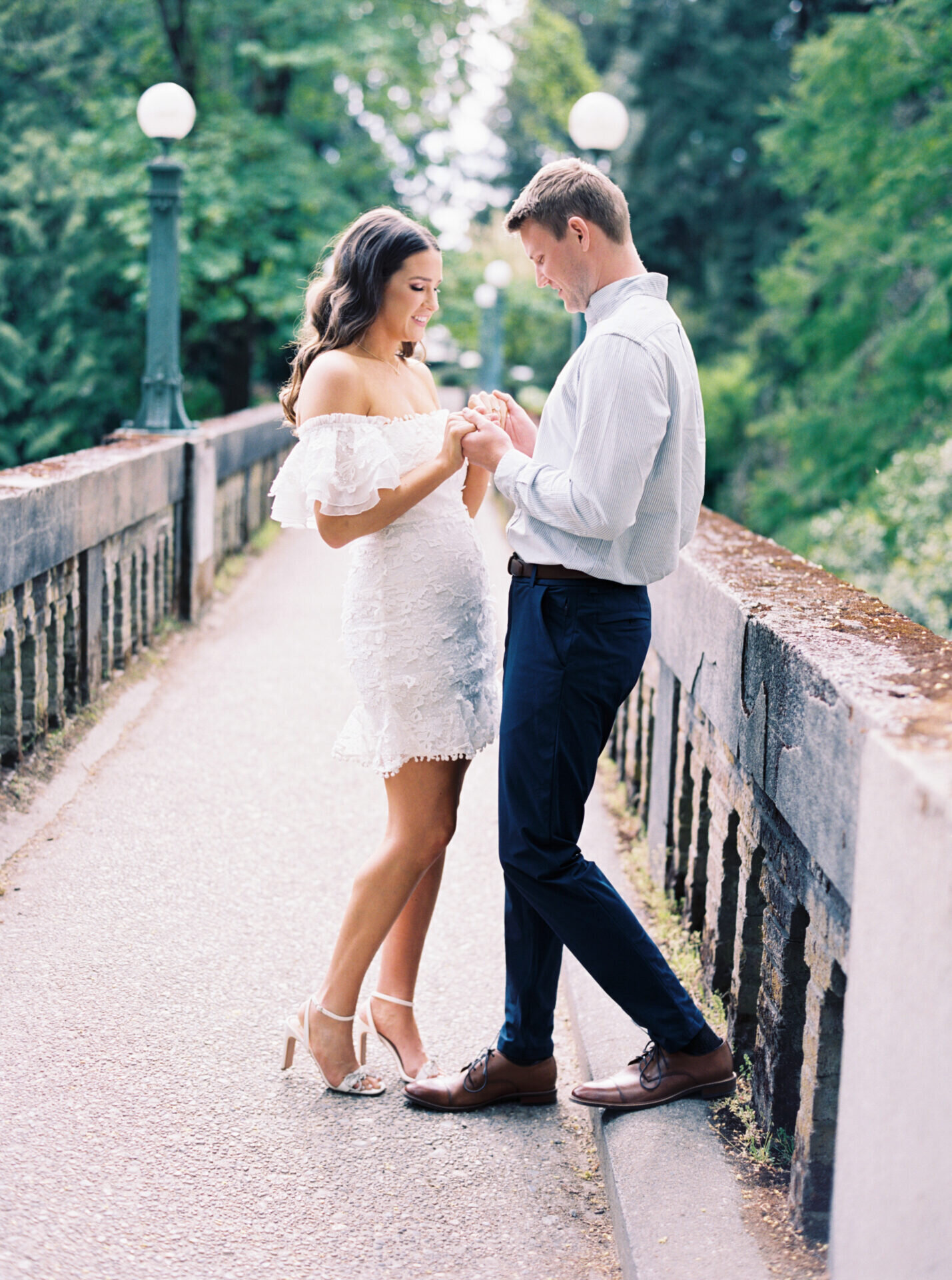 couple holding hands on the arboretum bridge in seattle