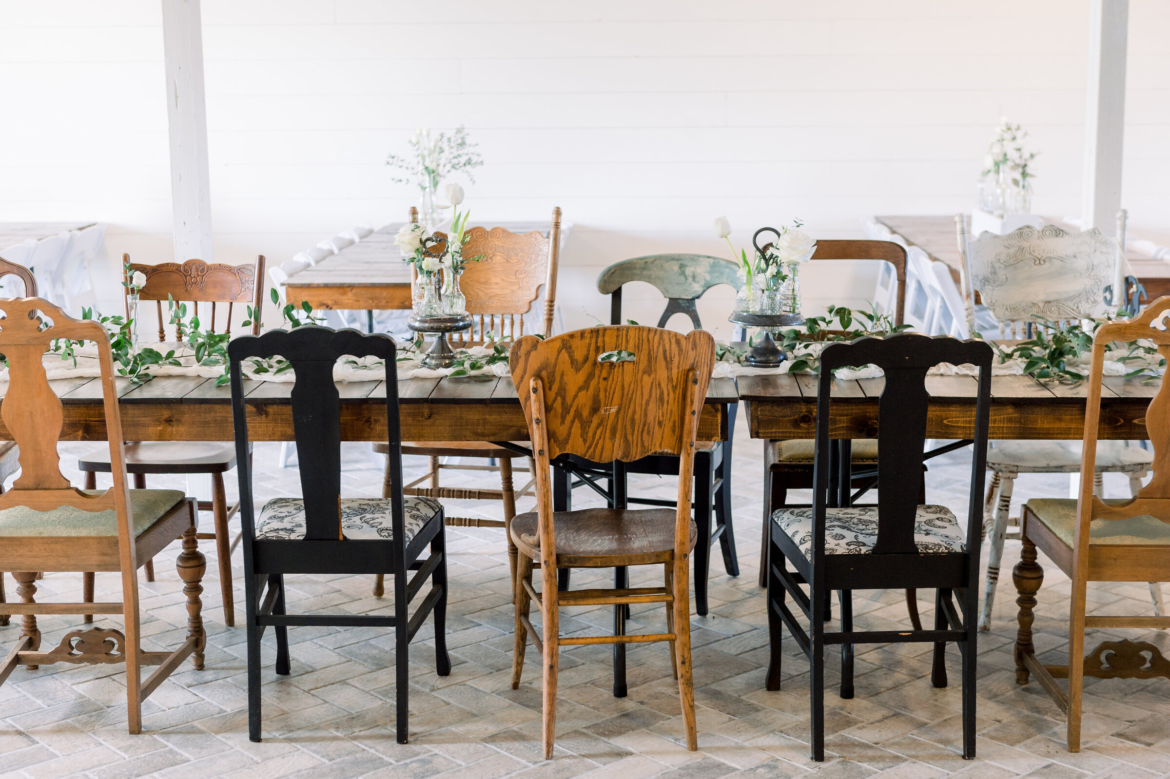 A set of vintage mismatched chairs at a wedding table