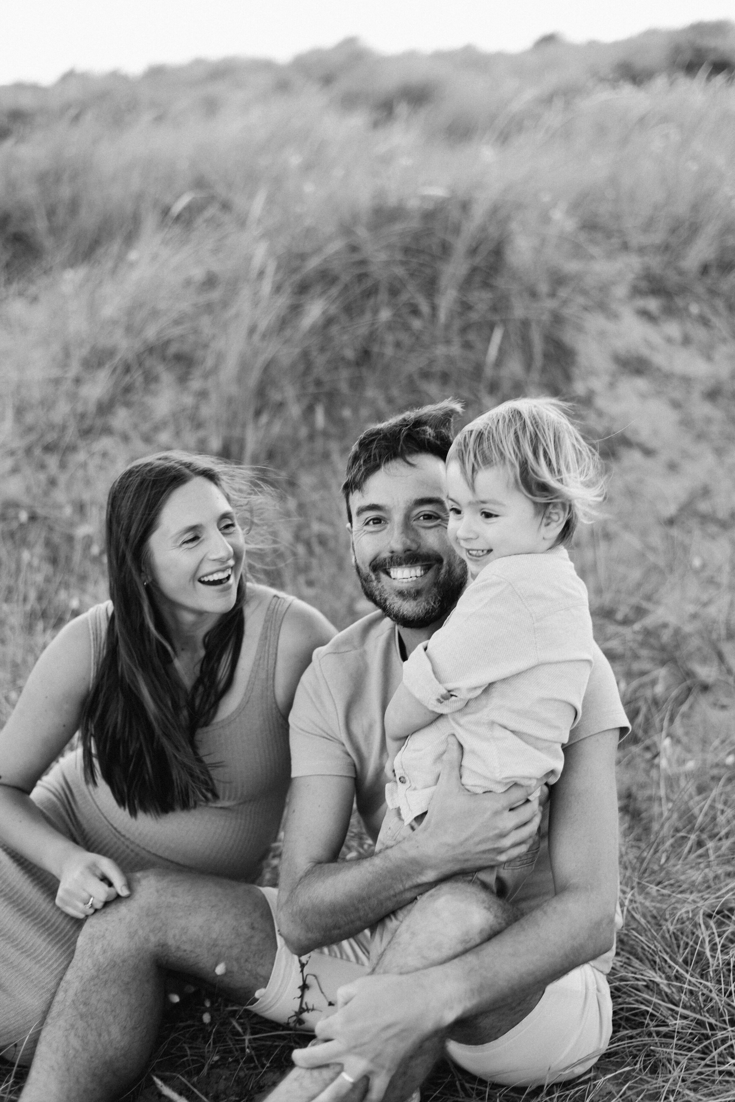 A family cuddling sitting down in a family photoshoot in Billingshurst