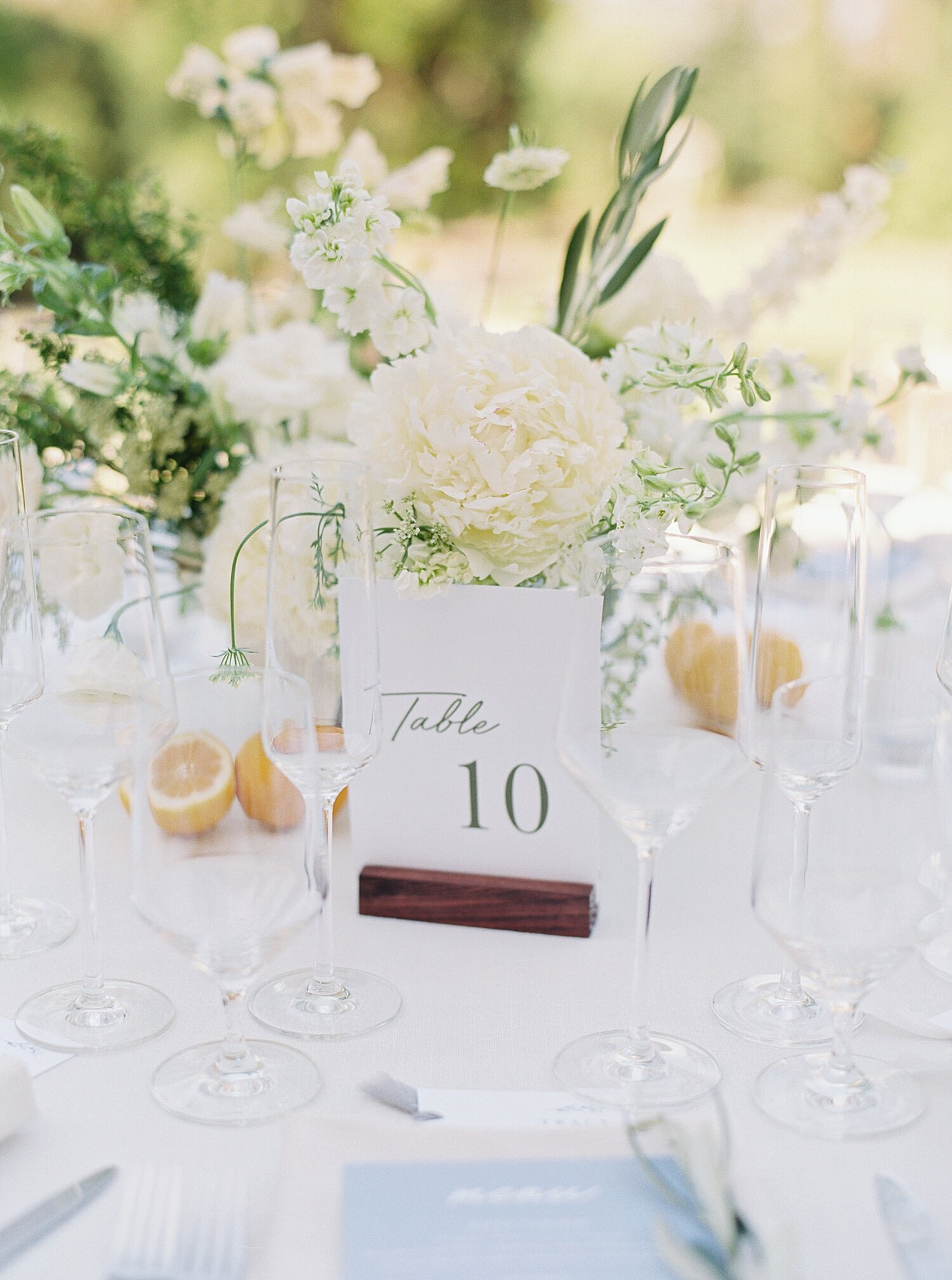 white wedding reception table numbers in brown wooden holder with white floral centerpiece