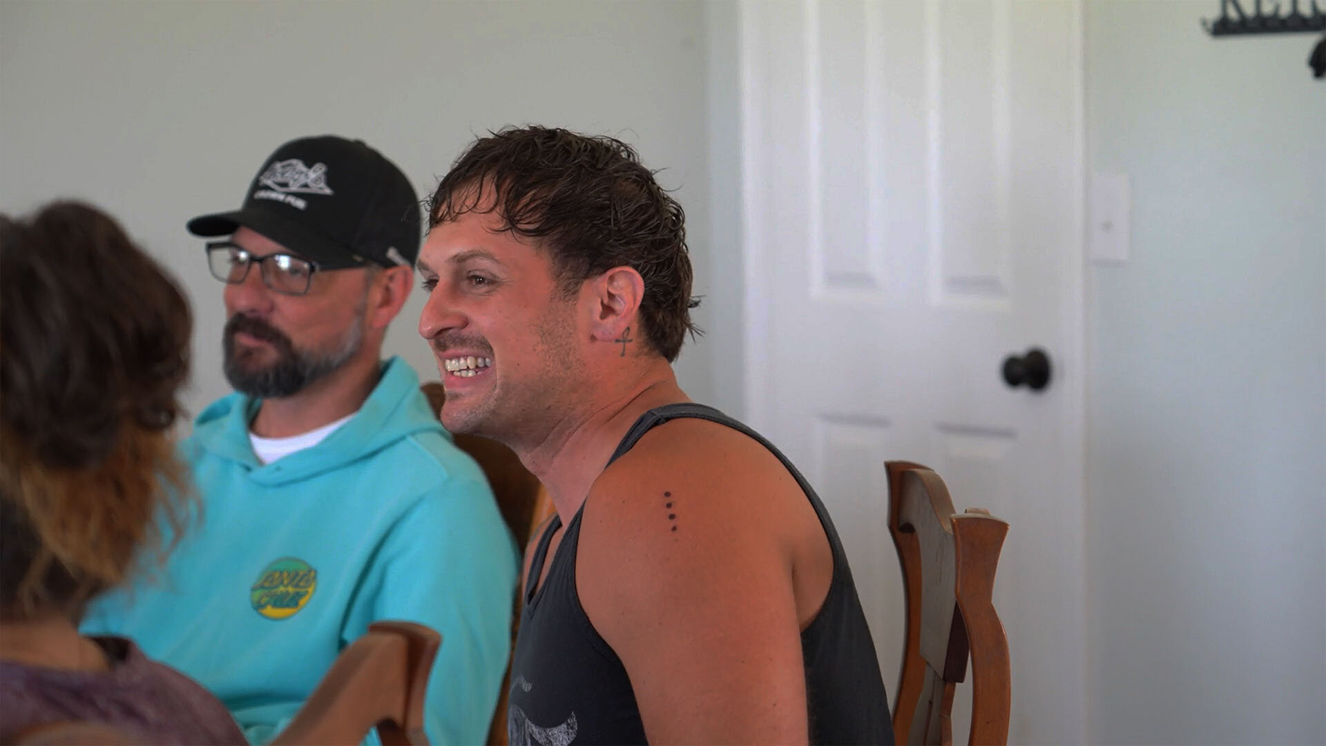 A photo of two men during an integration session at the end of the veteran retreat. One man has visible kambo dots on his arm.