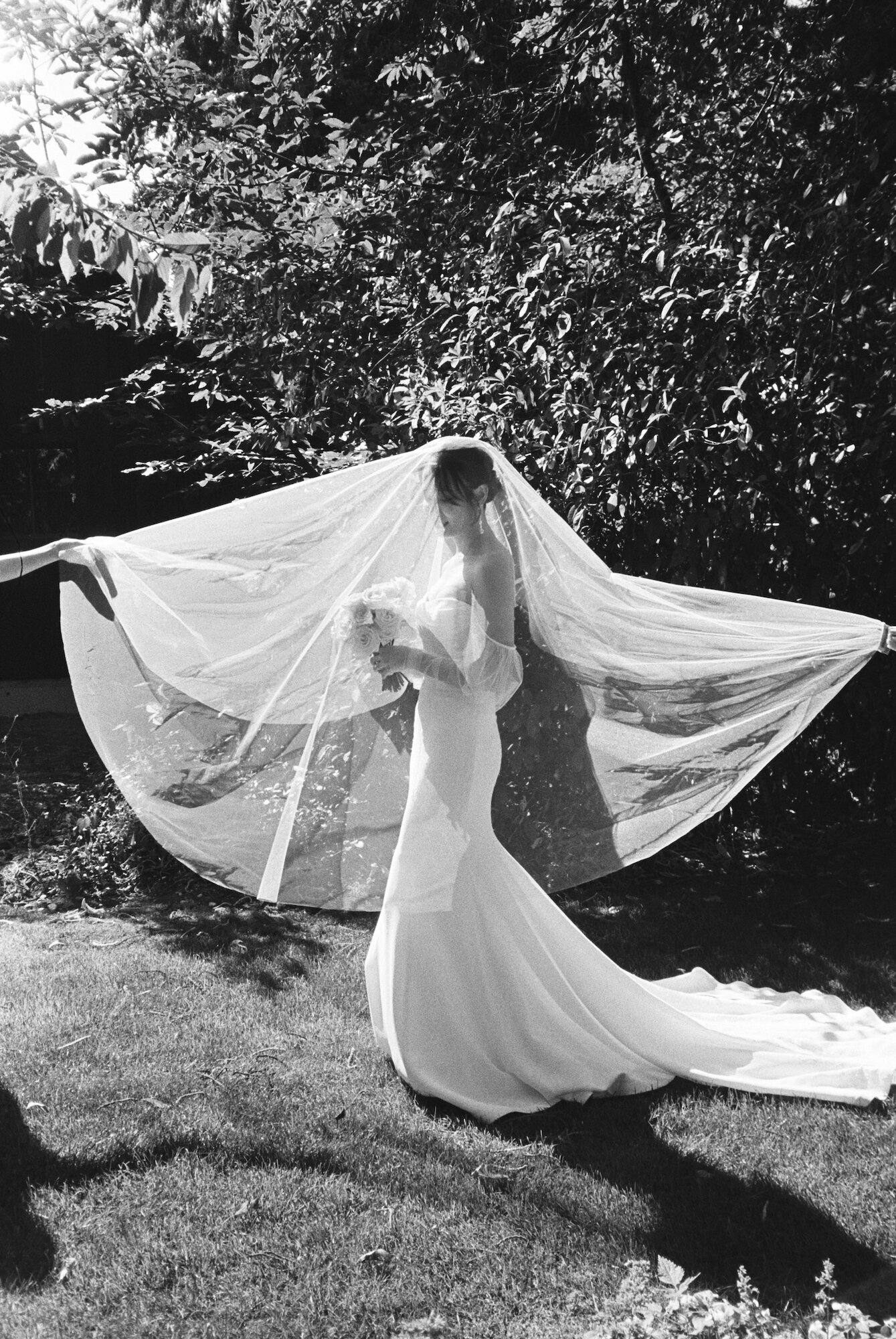 black and white point and shoot film photo of bride with veil over her