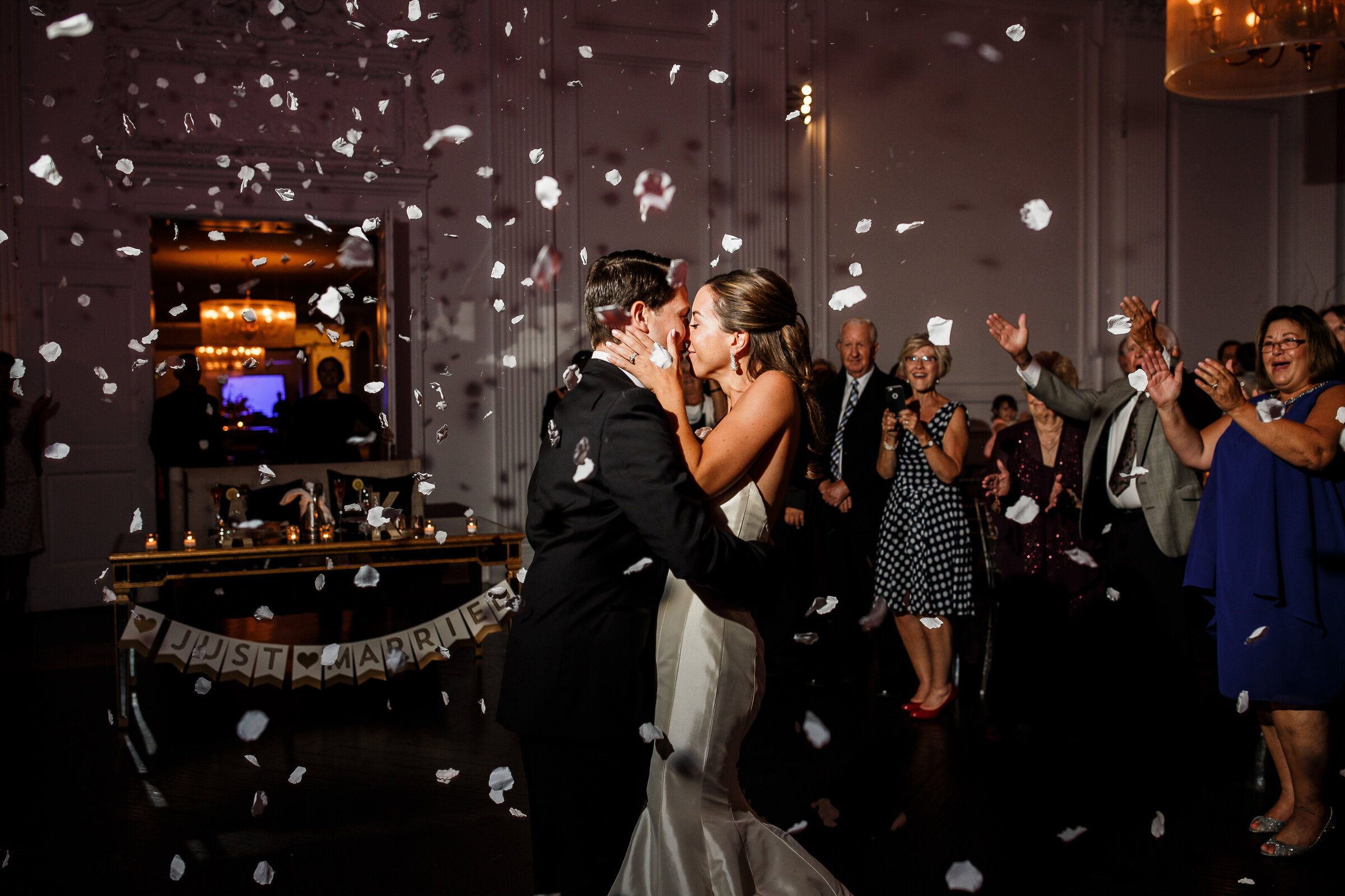 Bride and groom kiss during the rose petal cannon goes off at Down Town Club in Philadelphia