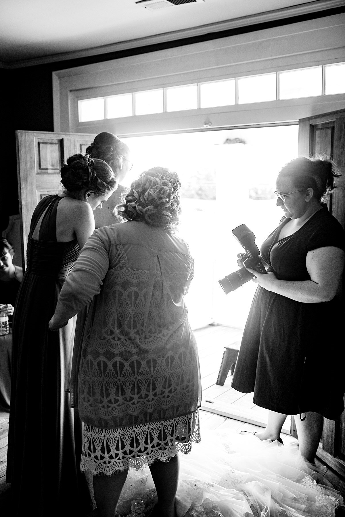 Black and White photo on photographer helping during getting ready