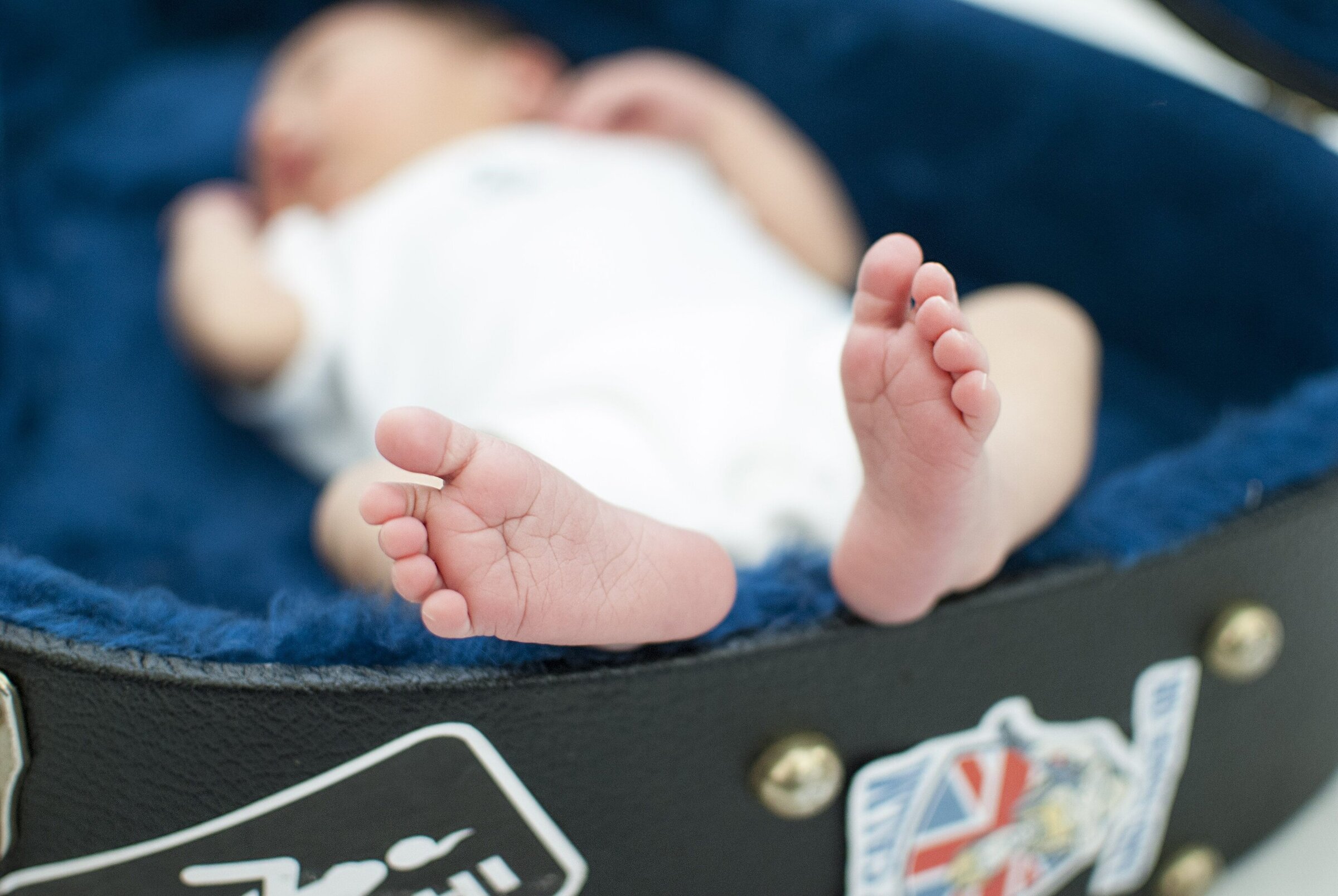 Newborn baby laying in a velvet lined guitar case