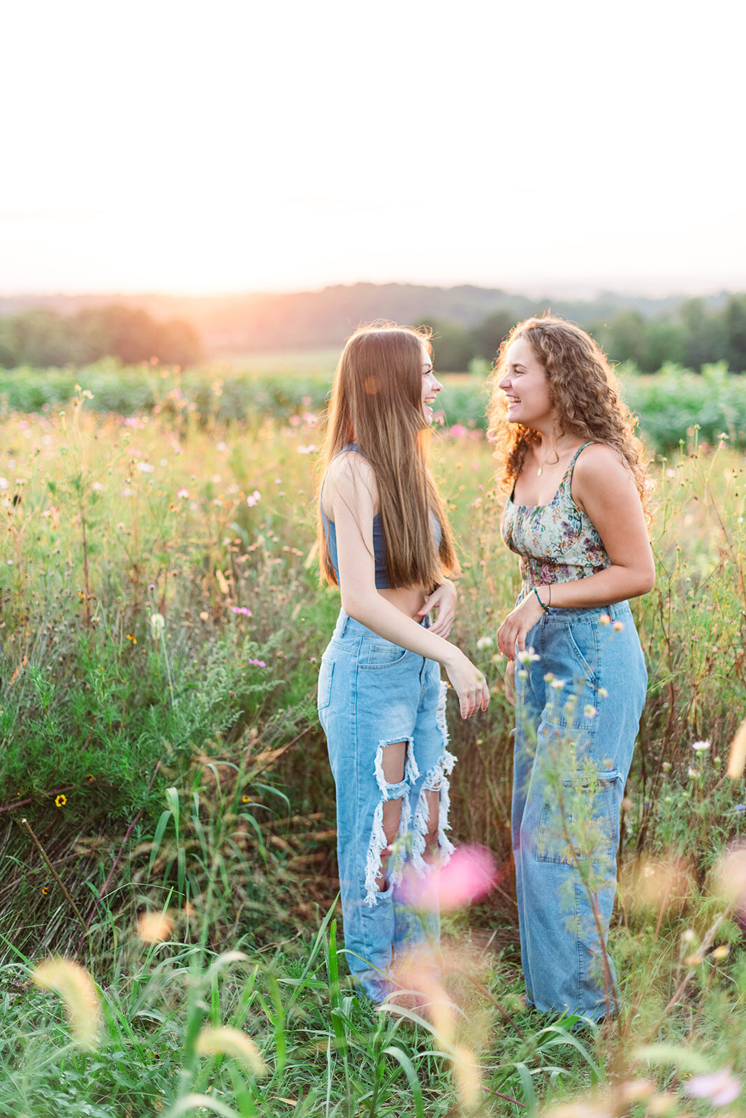 two senior best friends laughing in wildflowers by baltimore photographer