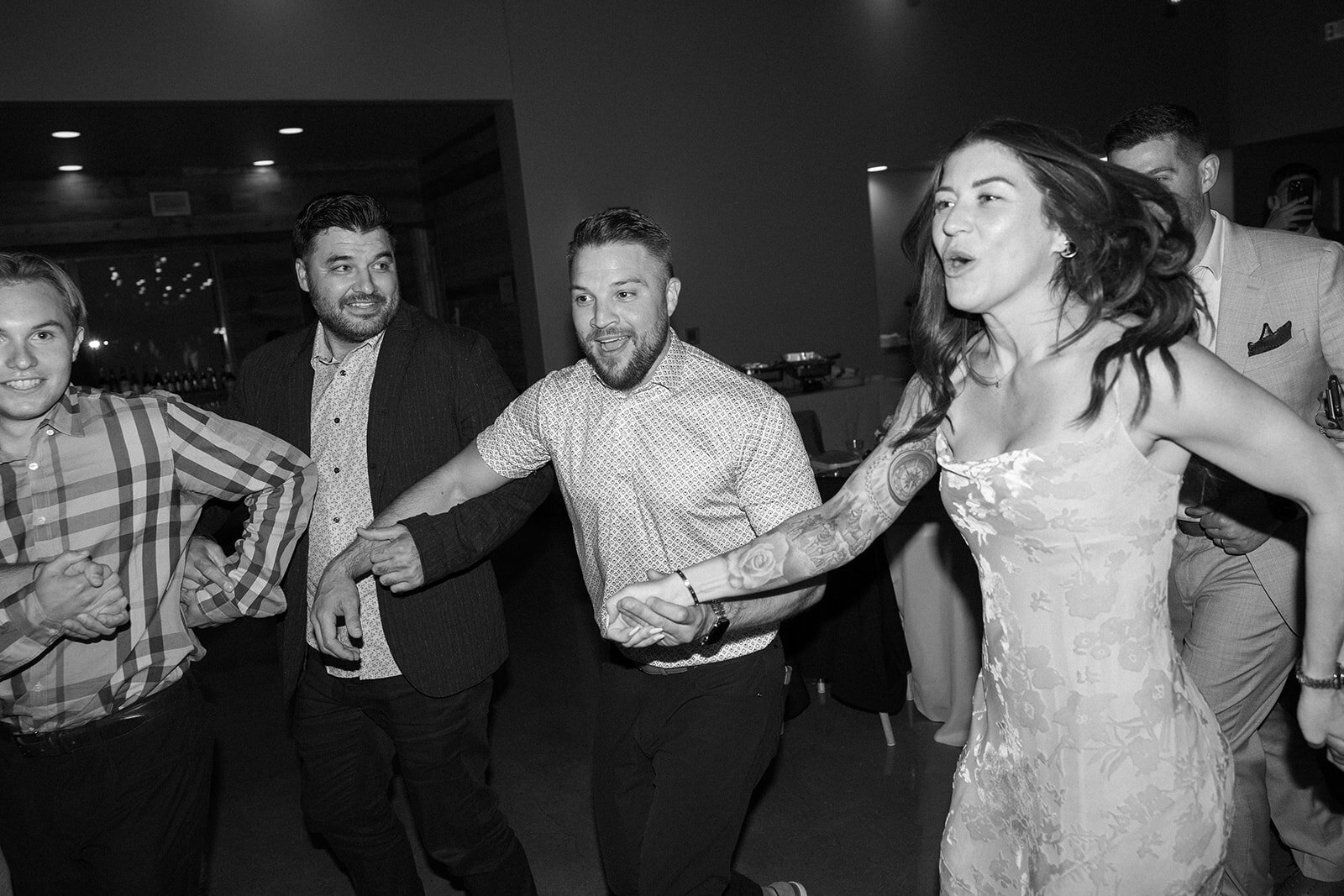 Guests holding hands forming a circle at the reception during the dancing.