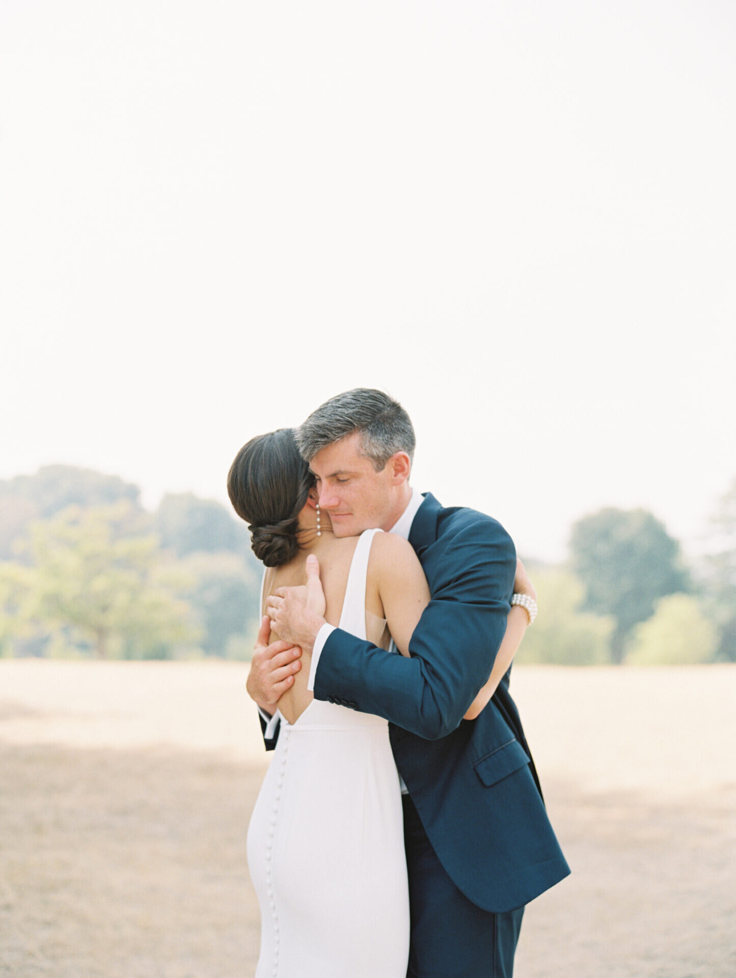 groom hugging bride at discovery park for first look