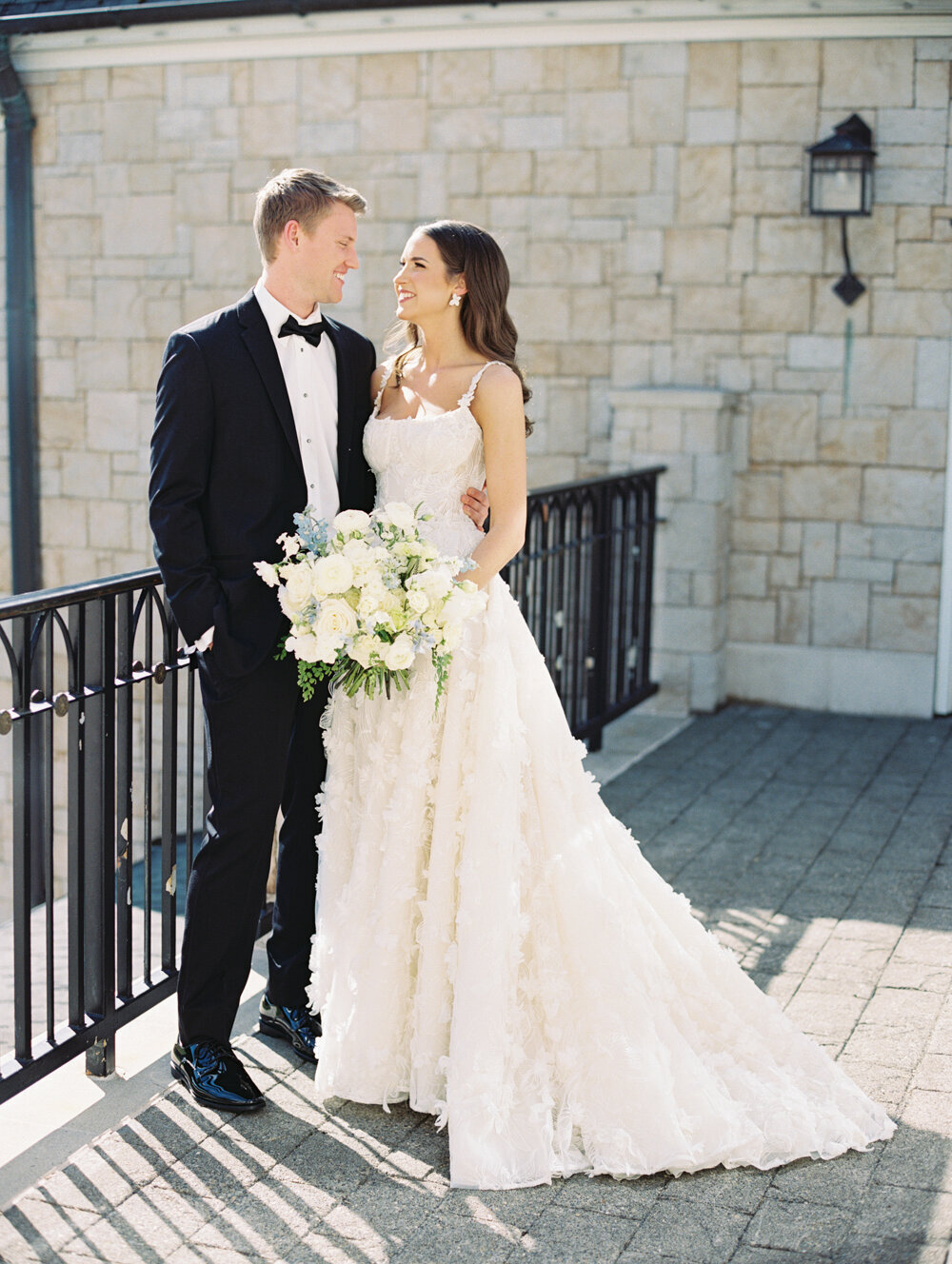bride and groom full body portraits black tux with white bouquet