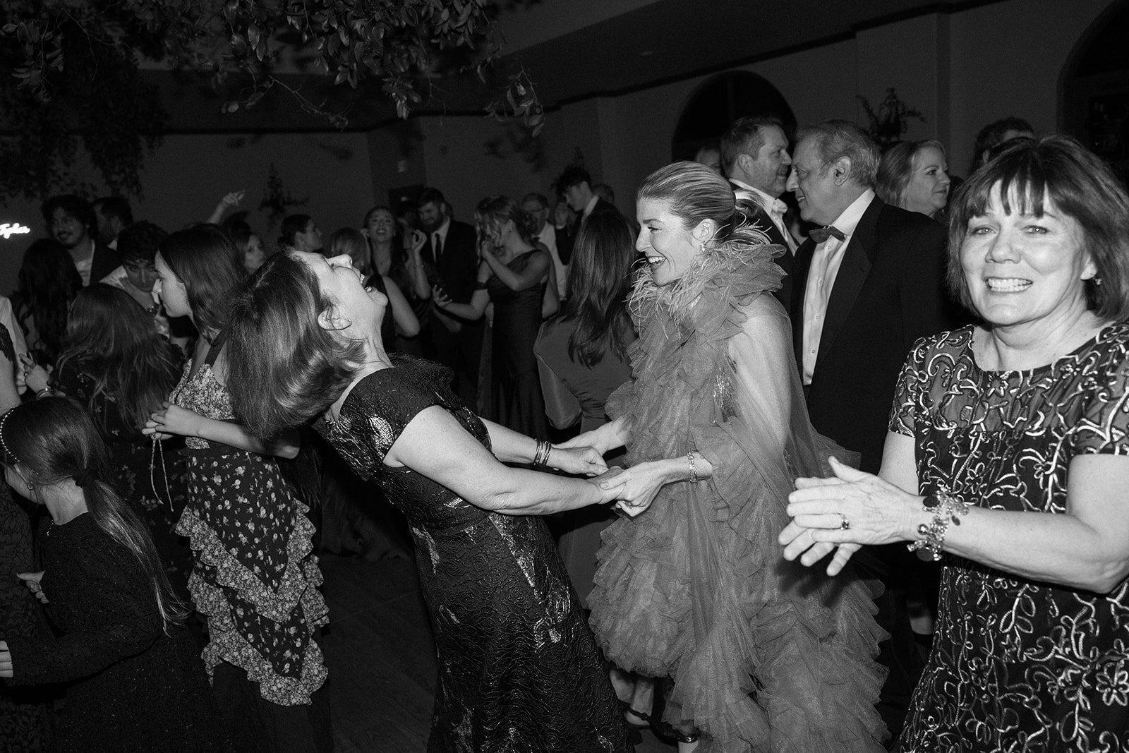 Two women guests at a wedding dancing and having the time of their lives. 