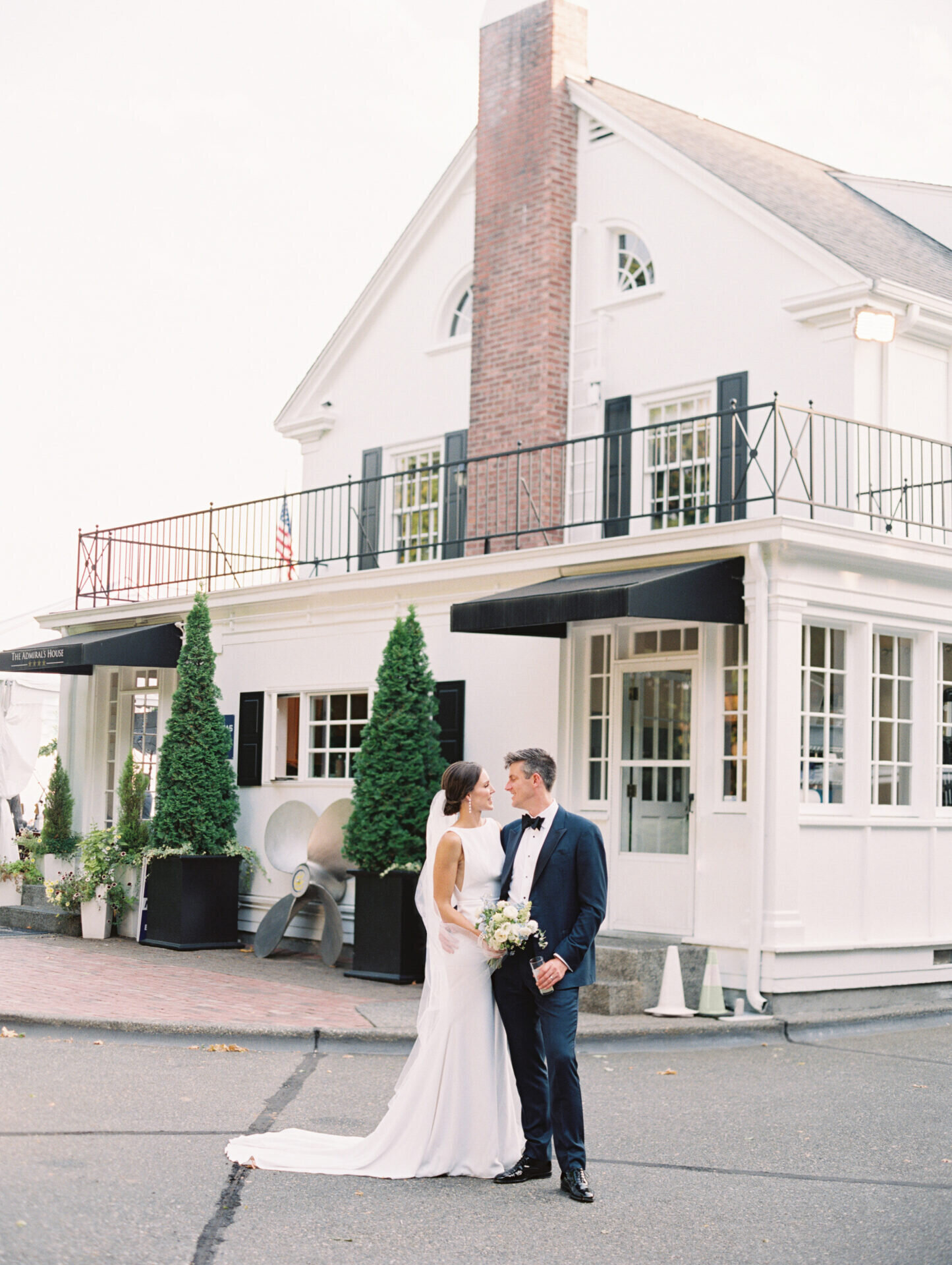 bride and groom looking at one another with historic venue behind them
