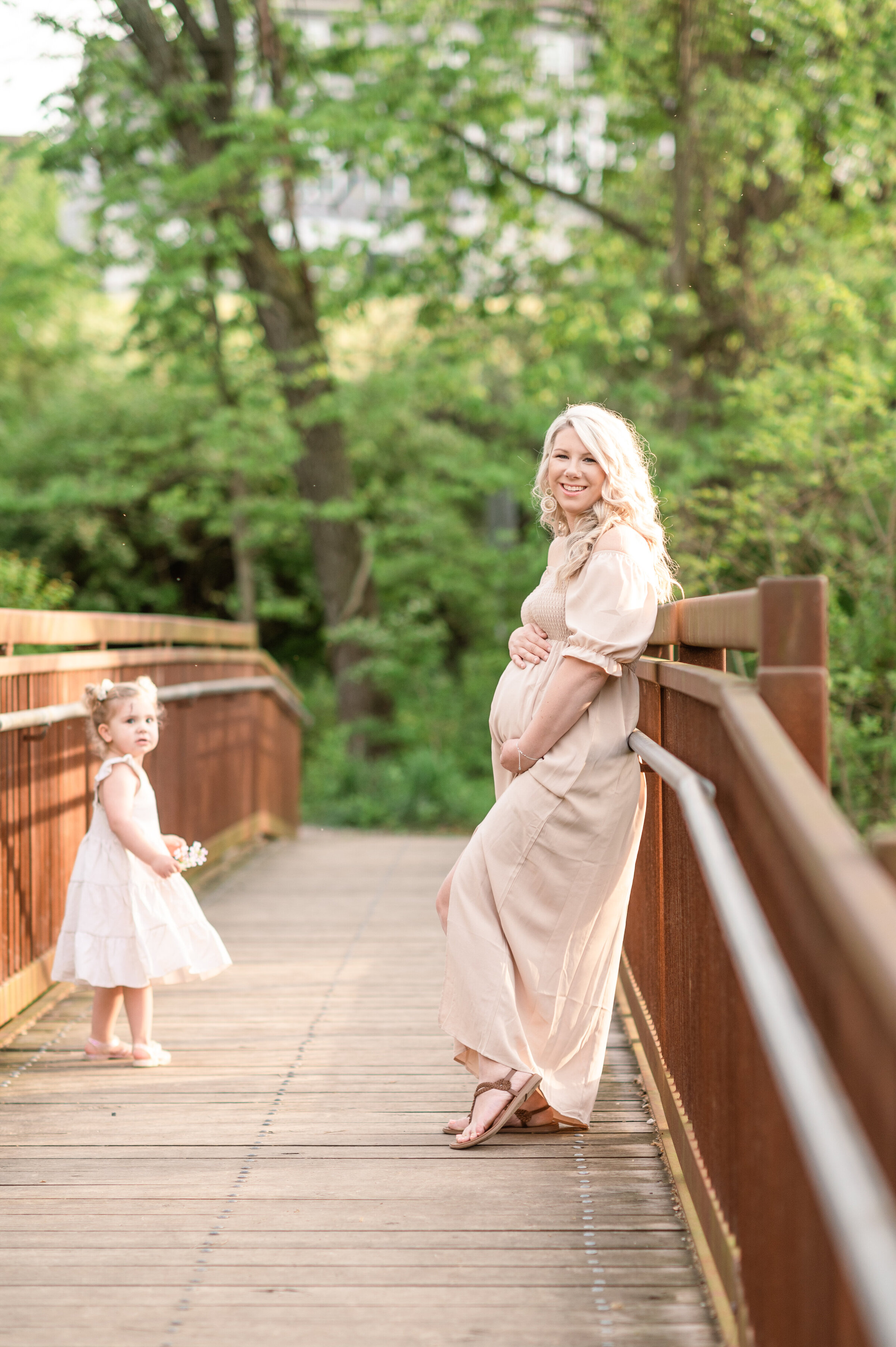 pregnant mother standing on a bridge with toddler daughter in lancaster pa
