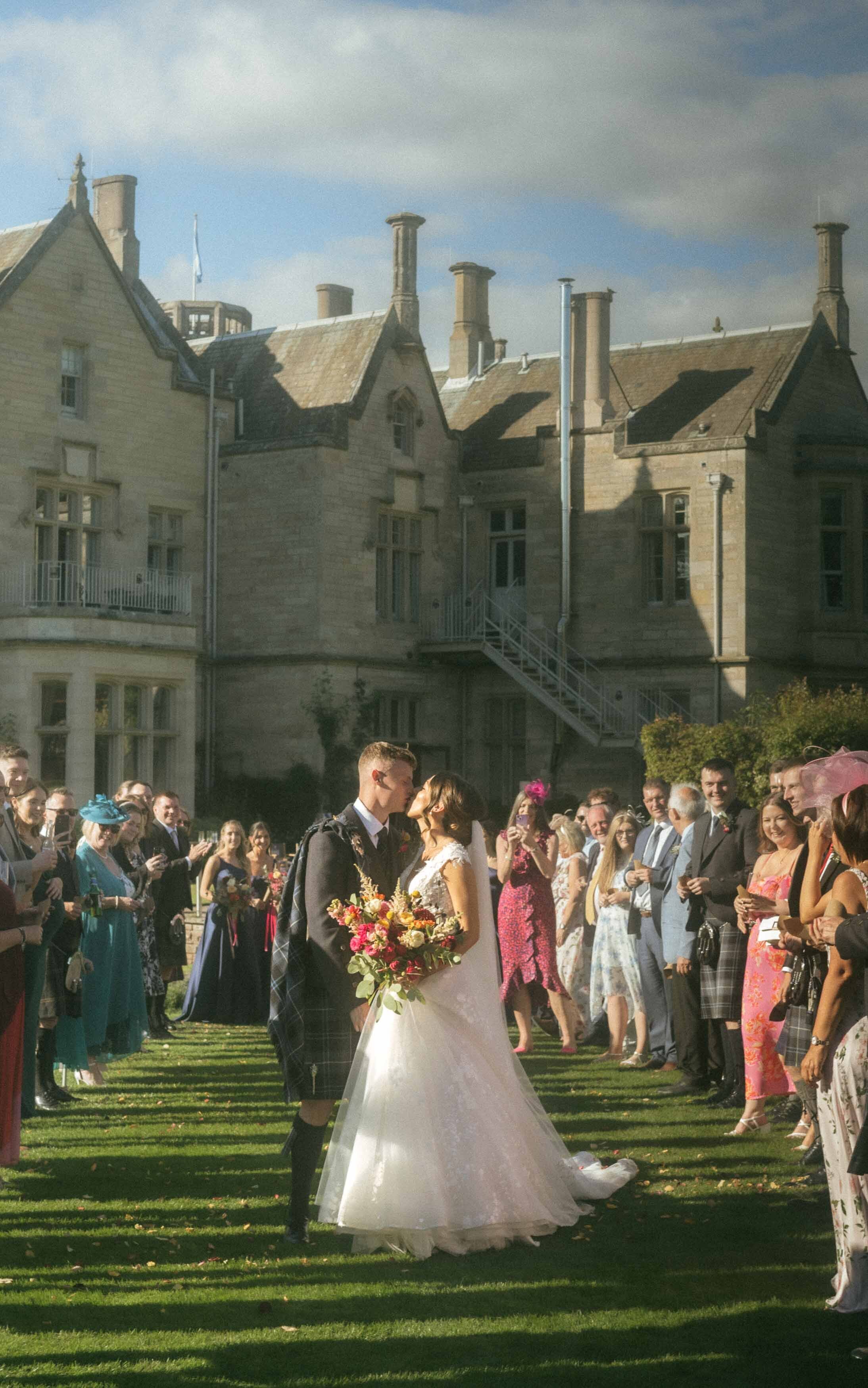 A joyful moment of a married couple kissing and celebrating with confetti at Schloss, capturing their love and excitement on their special day