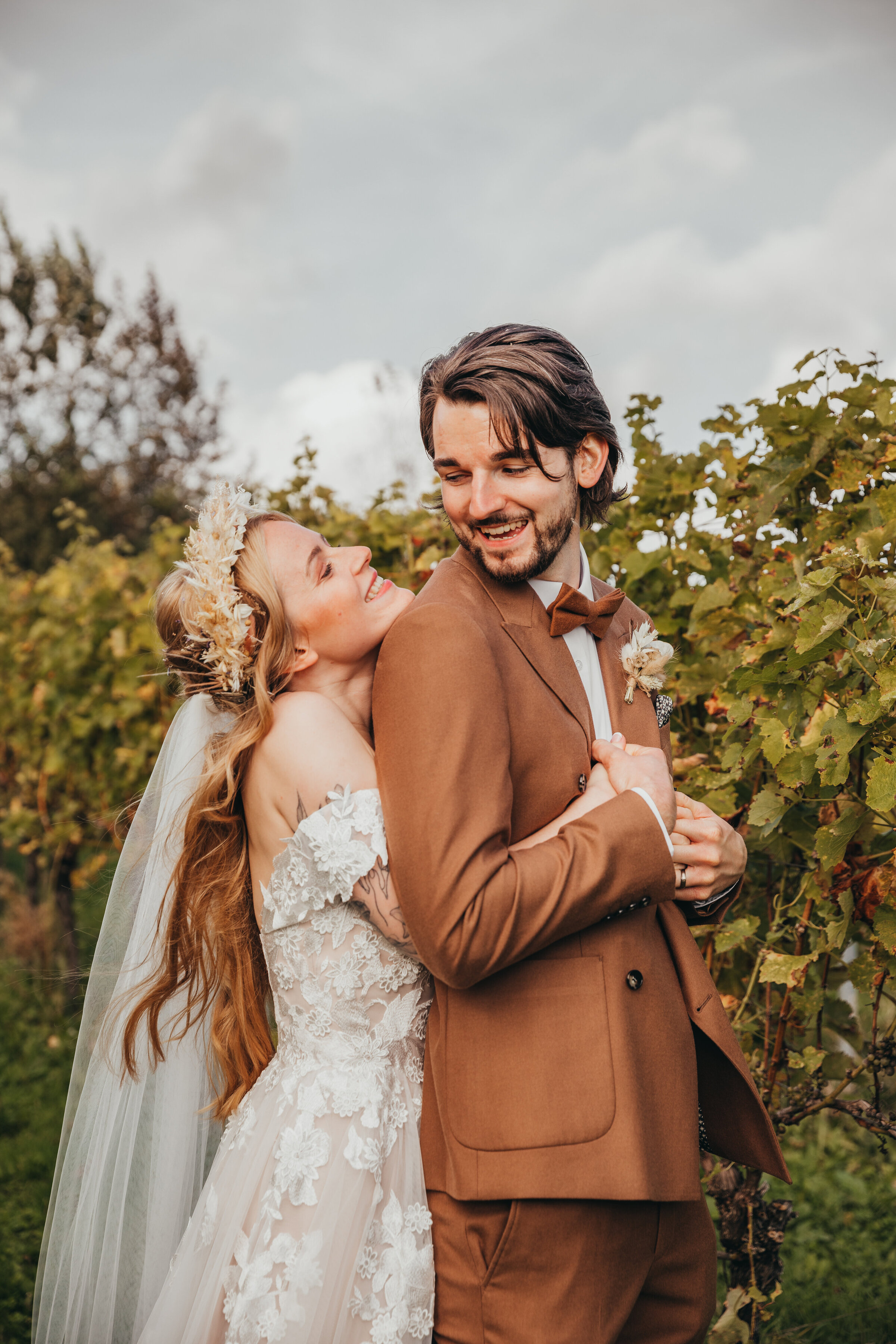 cute young newlywed couple hug in a vineyard
