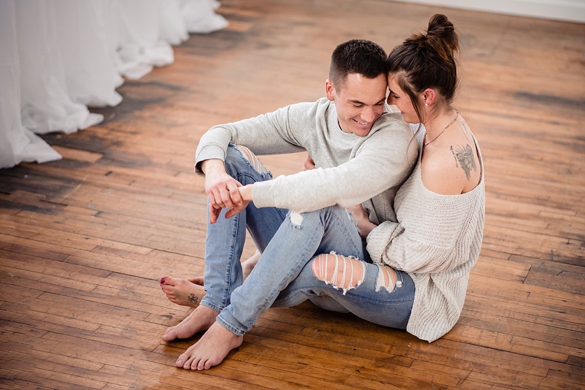 Lifestyle photo of couple snuggled together on a hardwood floor