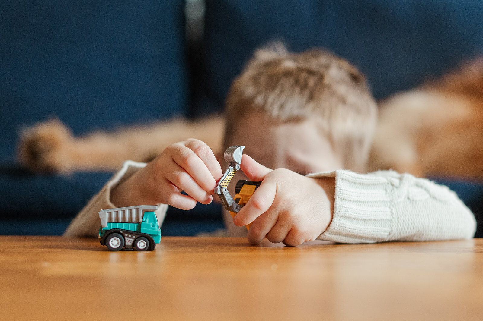 A child using a toy screwdriver on a wooden table during a candid Day in the Life photo session in Baltimore, Maryland.
