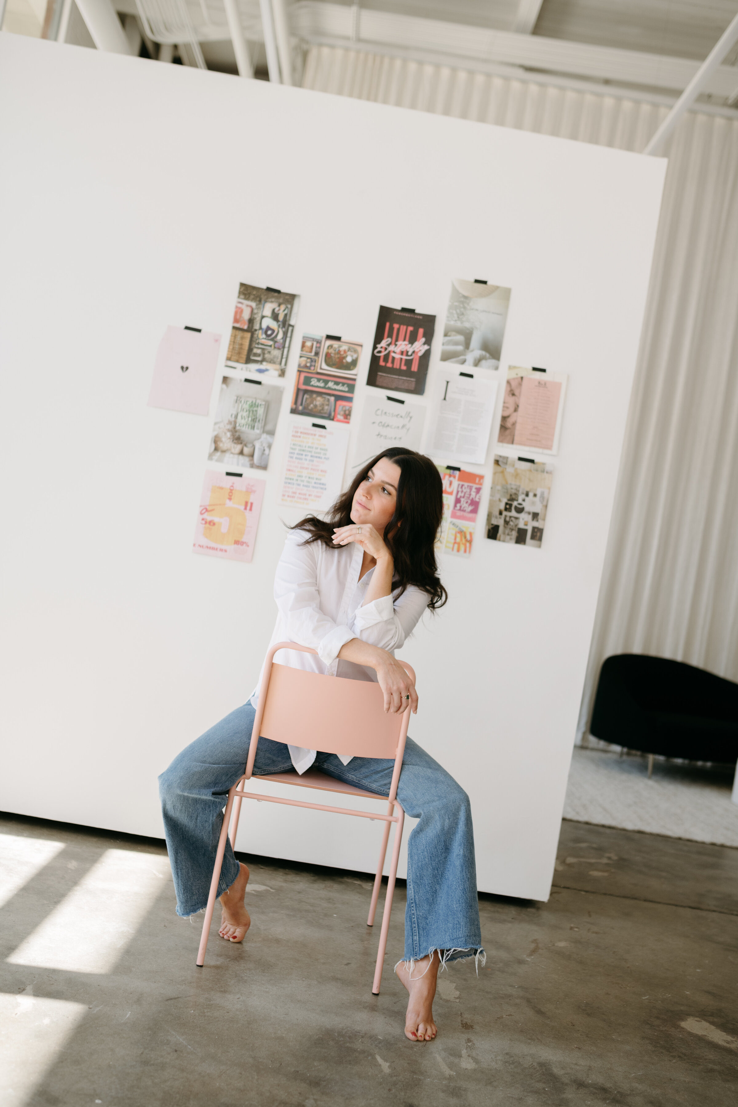 web designer sitting in front of mood board in a minimalist studio
