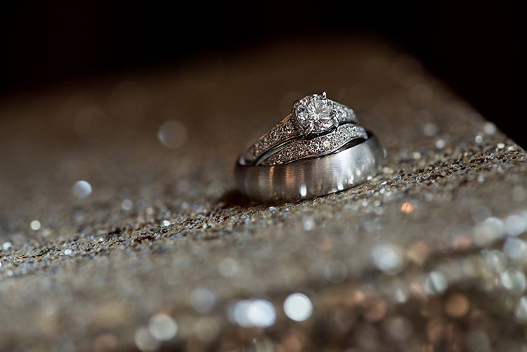 Wedding rings stacked together with silver glitter around them