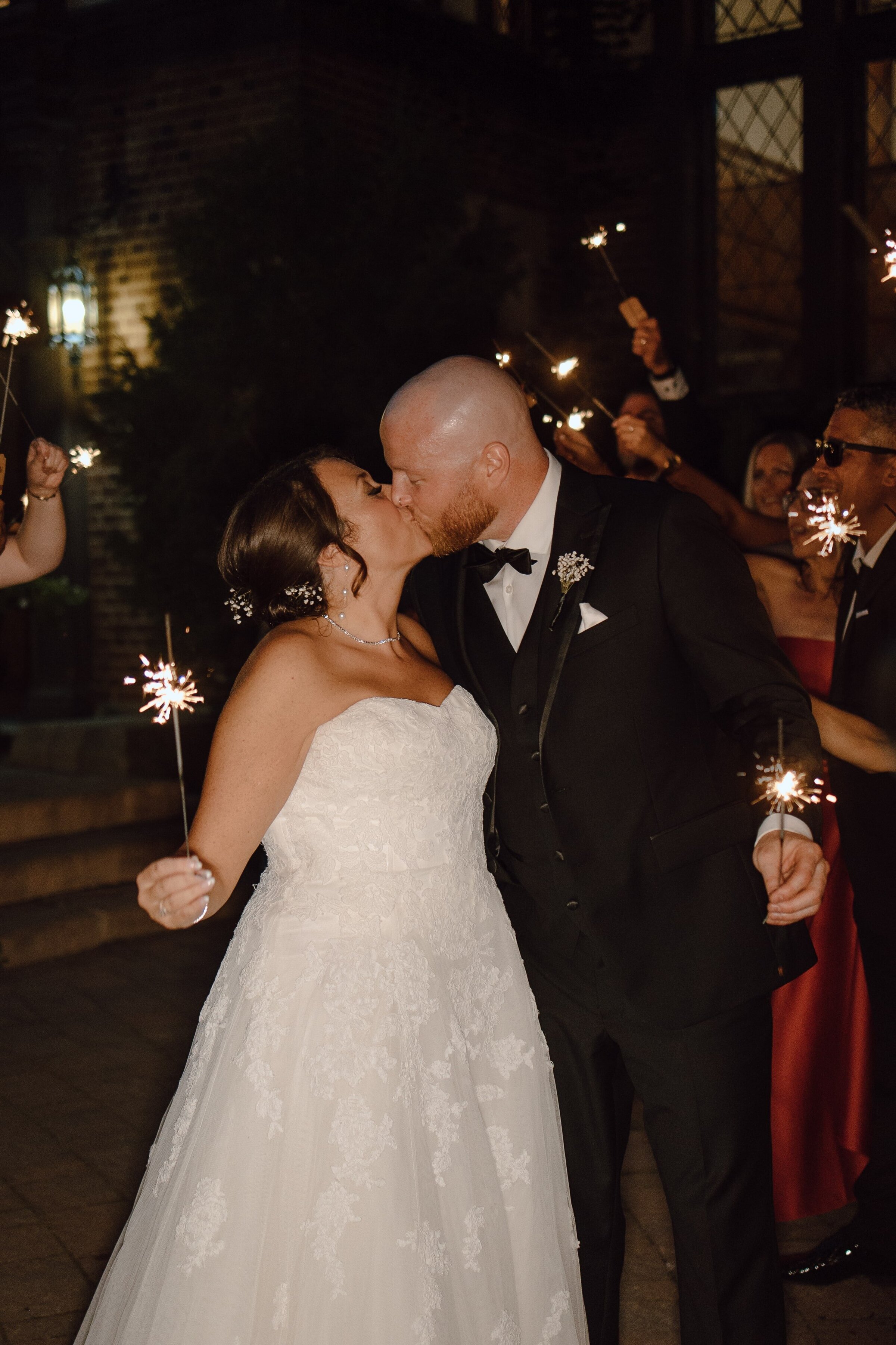 bride and groom kissing with sparklers