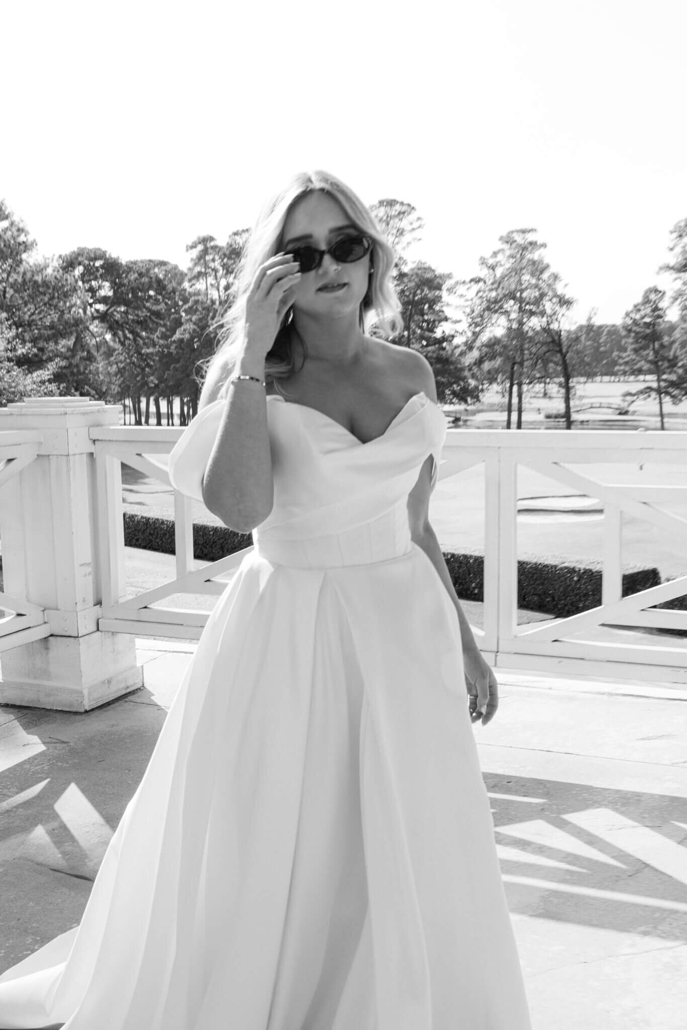 Black and white bridal portrait of a bride wearing sunglasses giving off a fun moody vibe