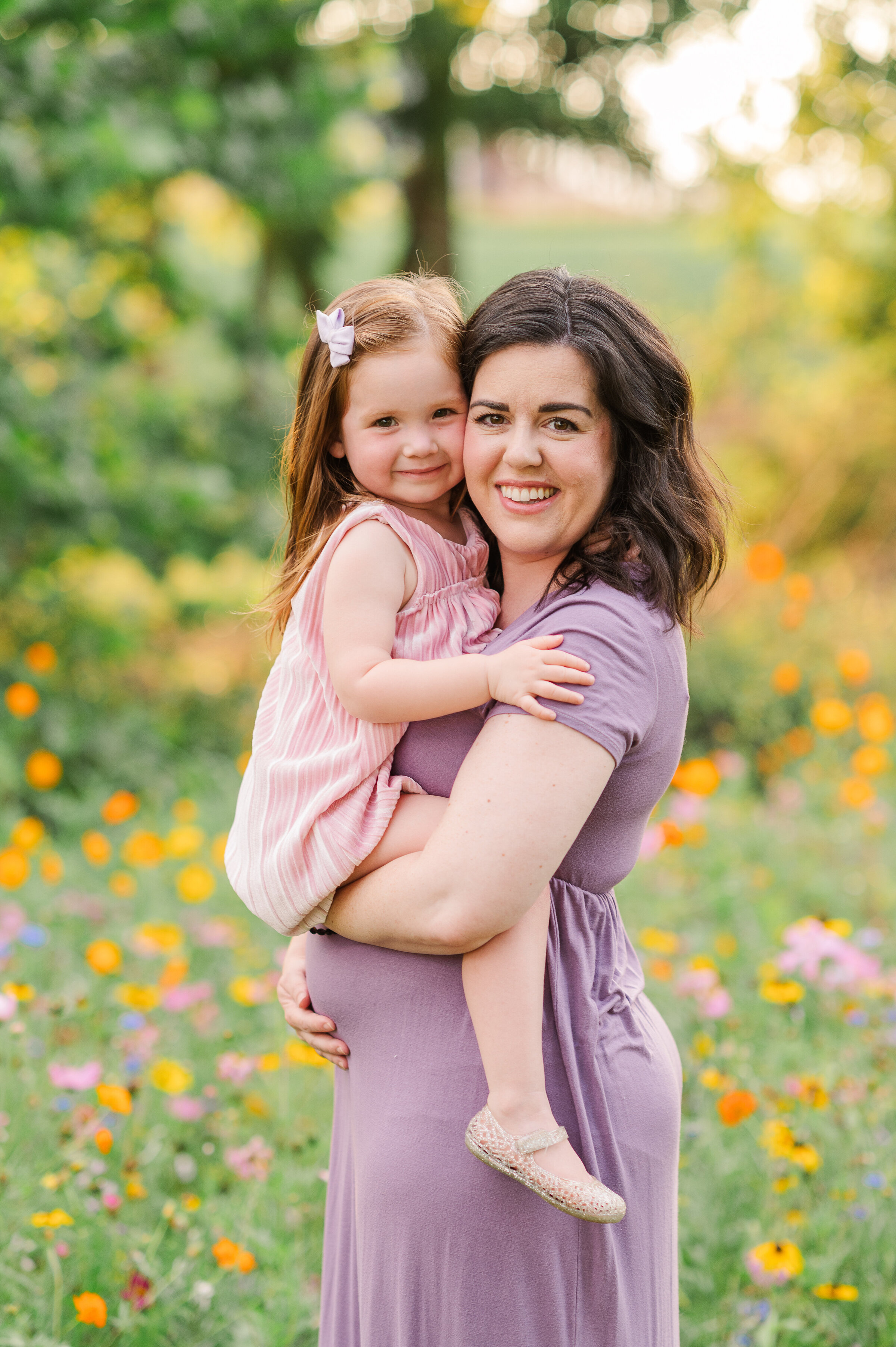 Mom hugging daughter with wildflowers in the background during summer mini session in Harrisburg, PA