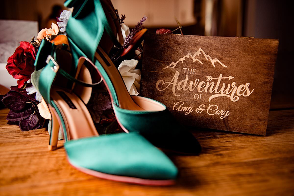 Brides green wedding heels  next to their wooden adventure box